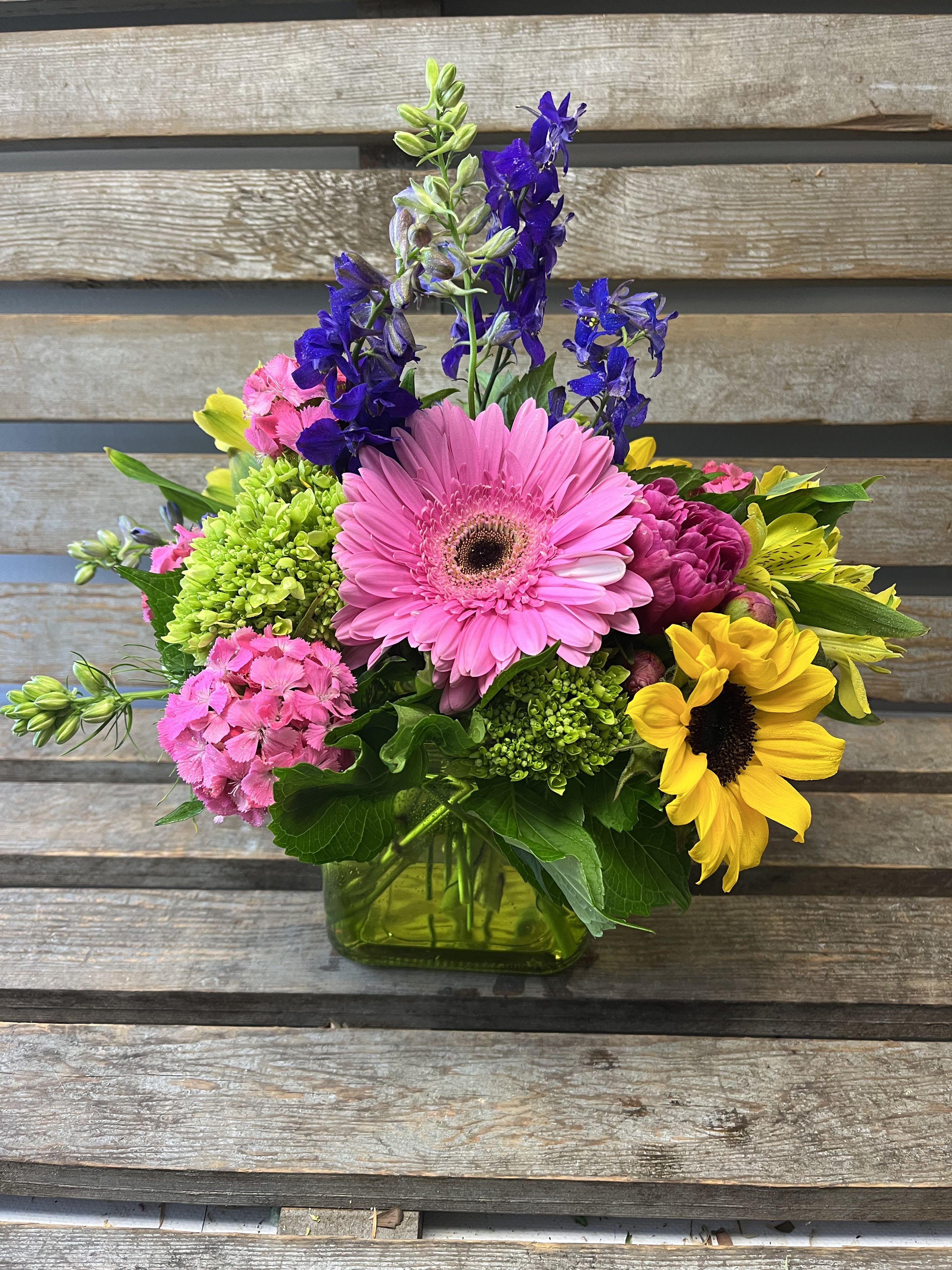 Summer cube  - A colored glass cube filled with designers choice of local summer flowers. Each week, the arrangement and the color of the cube will vary. A great mixture of flowers for a pop of color.