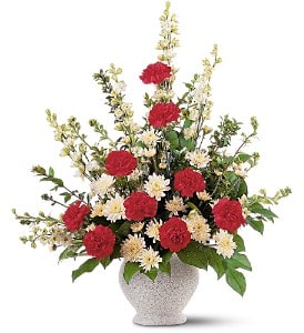 Red and white flowers arranged in a speckled vase