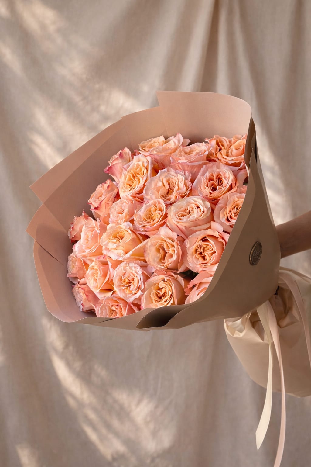 Bouquet of peach roses wrapped in beige paper