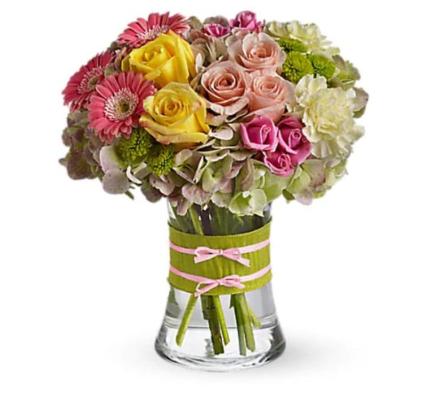 Mixed bouquet of roses, gerbera daisies, and hydrangeas in a glass vase