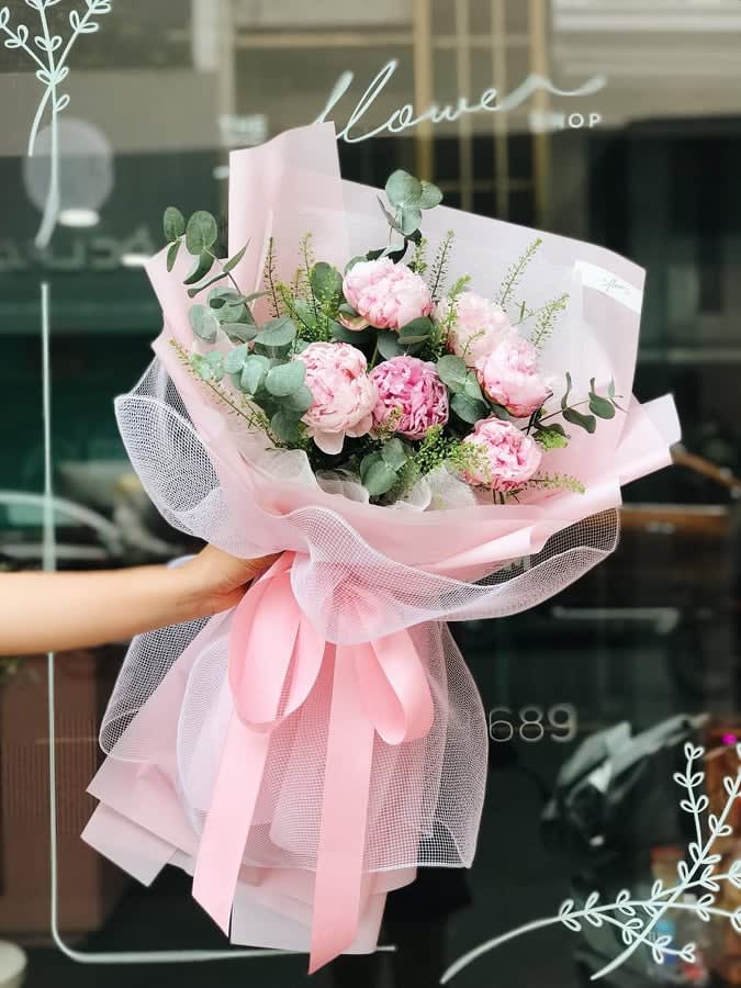 Pink peony bouquet wrapped in pale pink paper and tulle