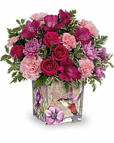 Sweet Hummingbird Bouquet - Inspired by a vintage flea market find, this charming glass cube is adorned with delightful botanical hummingbird imagery and filled with an equally enchanting rose bouquet. This beautiful bouquet includes hot pink spray roses, dark pink alstroemeria, lavender cushion spray chrysanthemums, pink carnations, miniature pink carnations, leatherleaf fern and pitta negra. Delivered in a Sweet Hummingbird cube. 