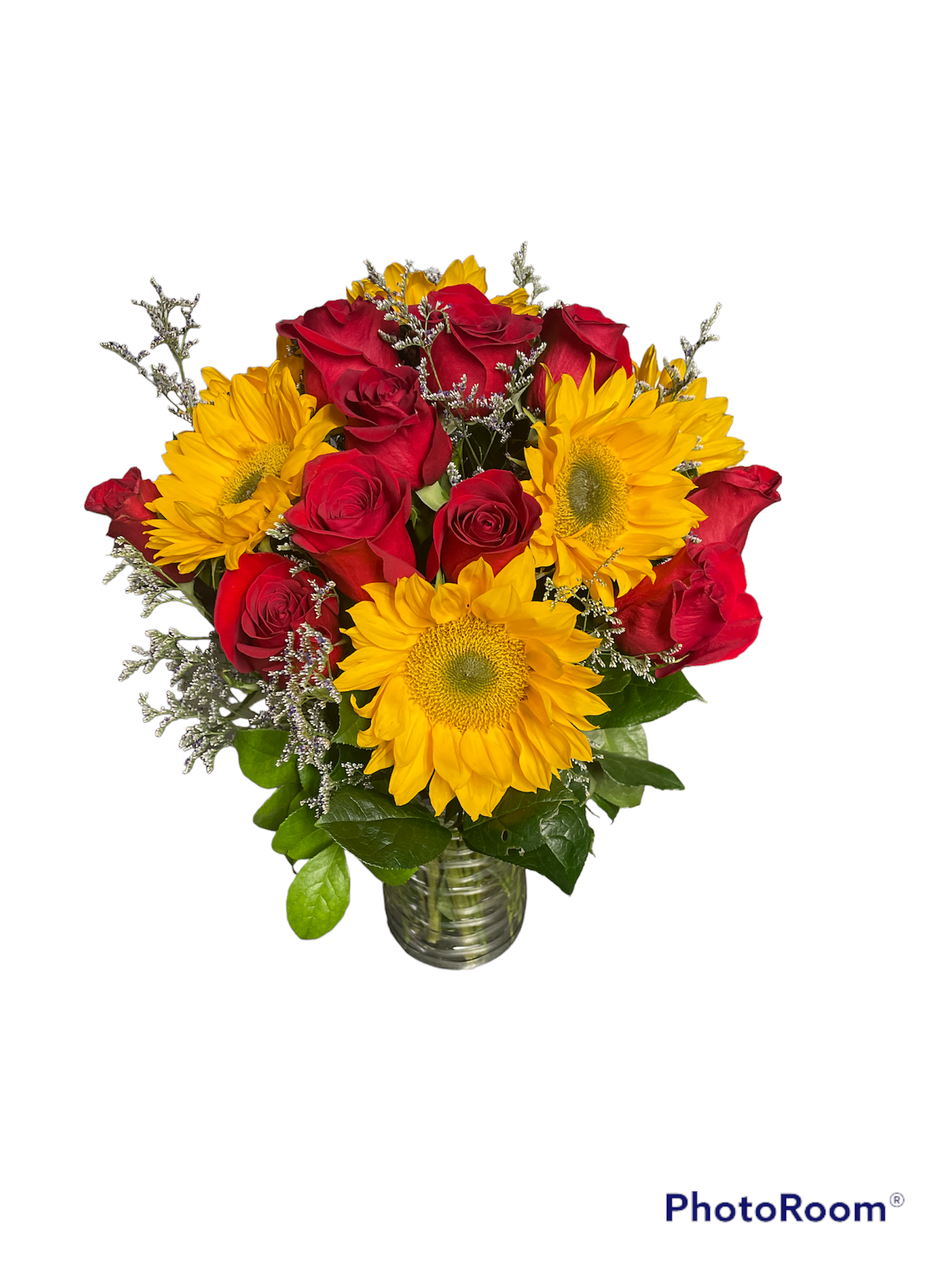 Bouquet of red roses and yellow sunflowers in a glass vase