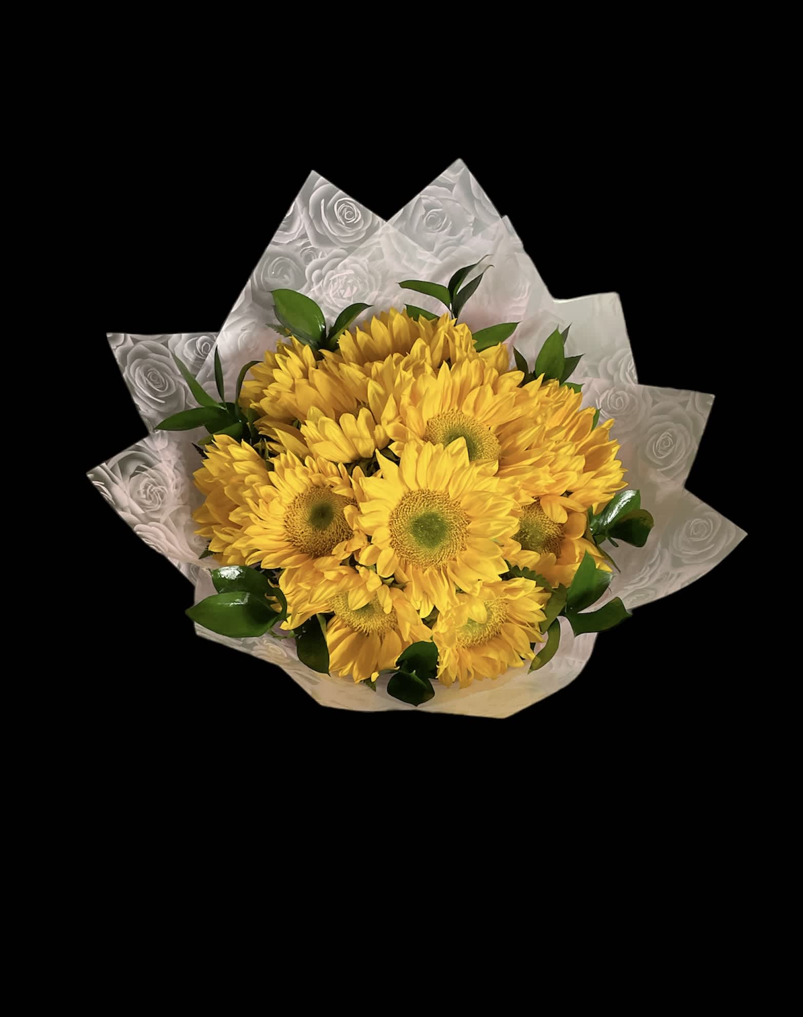 Bouquet of yellow daisies wrapped in patterned paper