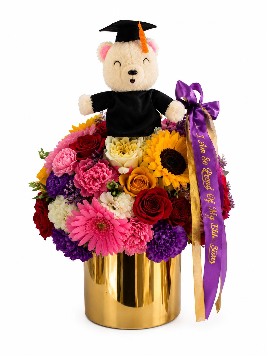 Radiant Achievement Bouquet - Looking for the perfect way to say "I'm so proud of you"? This show-stopping graduation arrangement is designed to bring pure joy to your favorite graduate. Nestled inside a sleek, reflective gold vase is a vibrant explosion of premium blooms—including bold sunflowers, rich red roses, bright pink gerbera daisies, and lush carnations.  Topped with an adorable keepsake graduation teddy bear in a cap and gown, it’s a beautiful tribute to all their hard work.