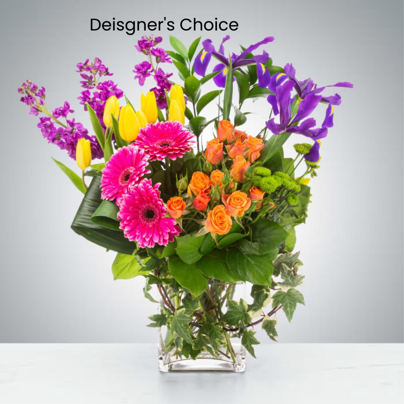 The Sandbar Vase - A designer’s choice arrangement featuring a fresh seasonal mix of blooms and greenery styled in a clear gathered square vase. Inspired by soft coastal colors and breezy beach days, each arrangement is uniquely designed and flower varieties may vary based on availability.