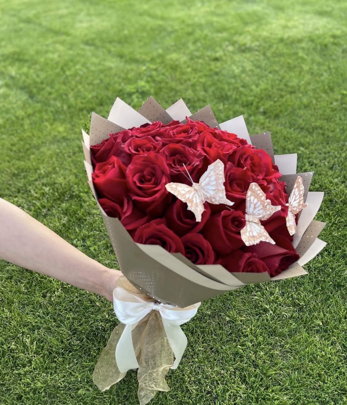 25 Red Roses with Gold Butterflies - Embrace the grandeur of tradition with our Ramo Buchon – a lavish tribute to love, celebration, and unapologetic luxury. This opulent bouquet features 25 velvety red roses, each bloom handpicked for its richness and depth, symbolizing passion, respect, and timeless devotion. Adorned with shimmering gold butterflies, this arrangement elevates the classic Ramo Buchon style with a modern, magical twist, perfect for those who demand nothing less than extraordinary.