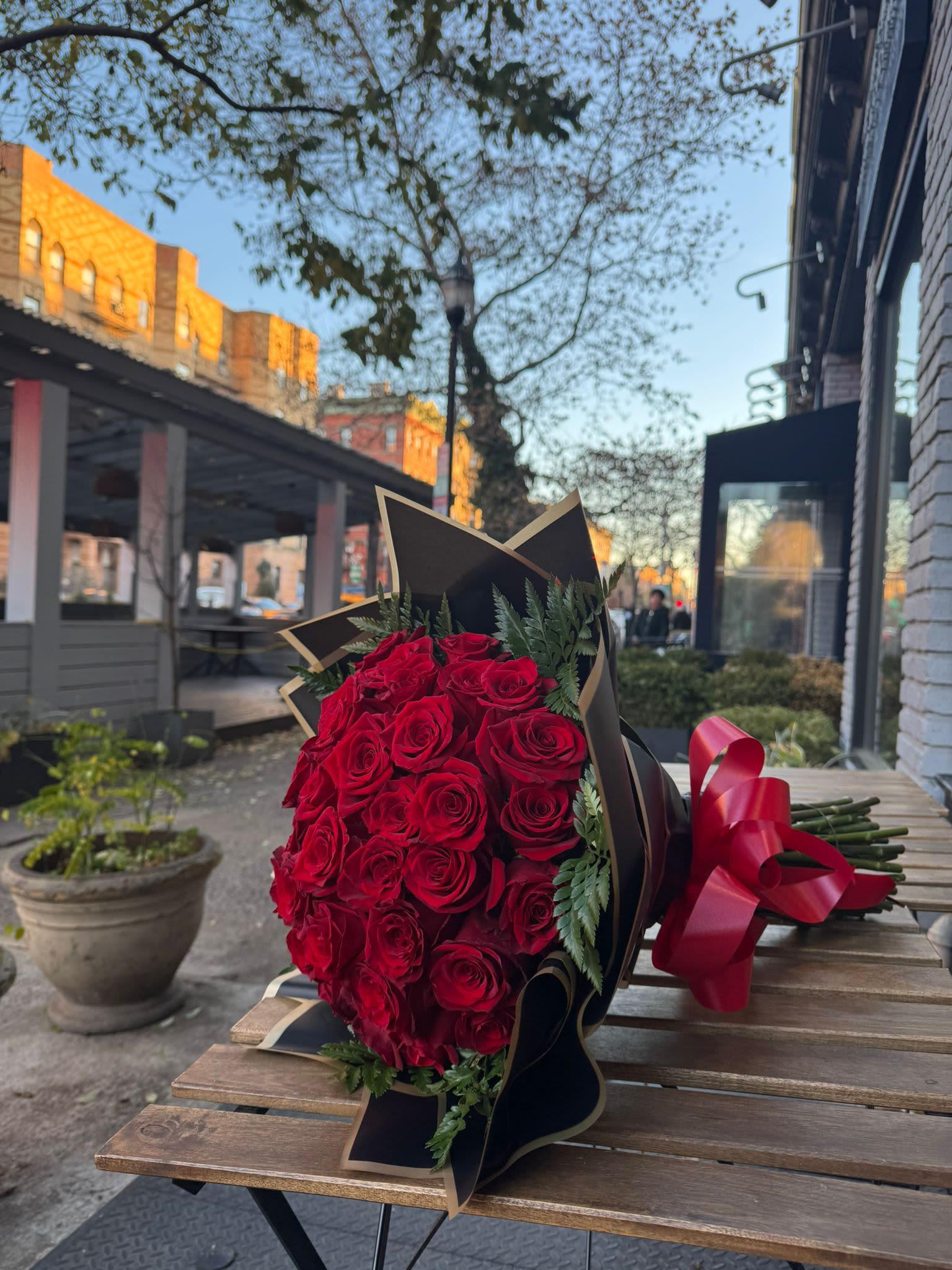 Bouquet of red roses wrapped in black paper with a red ribbon