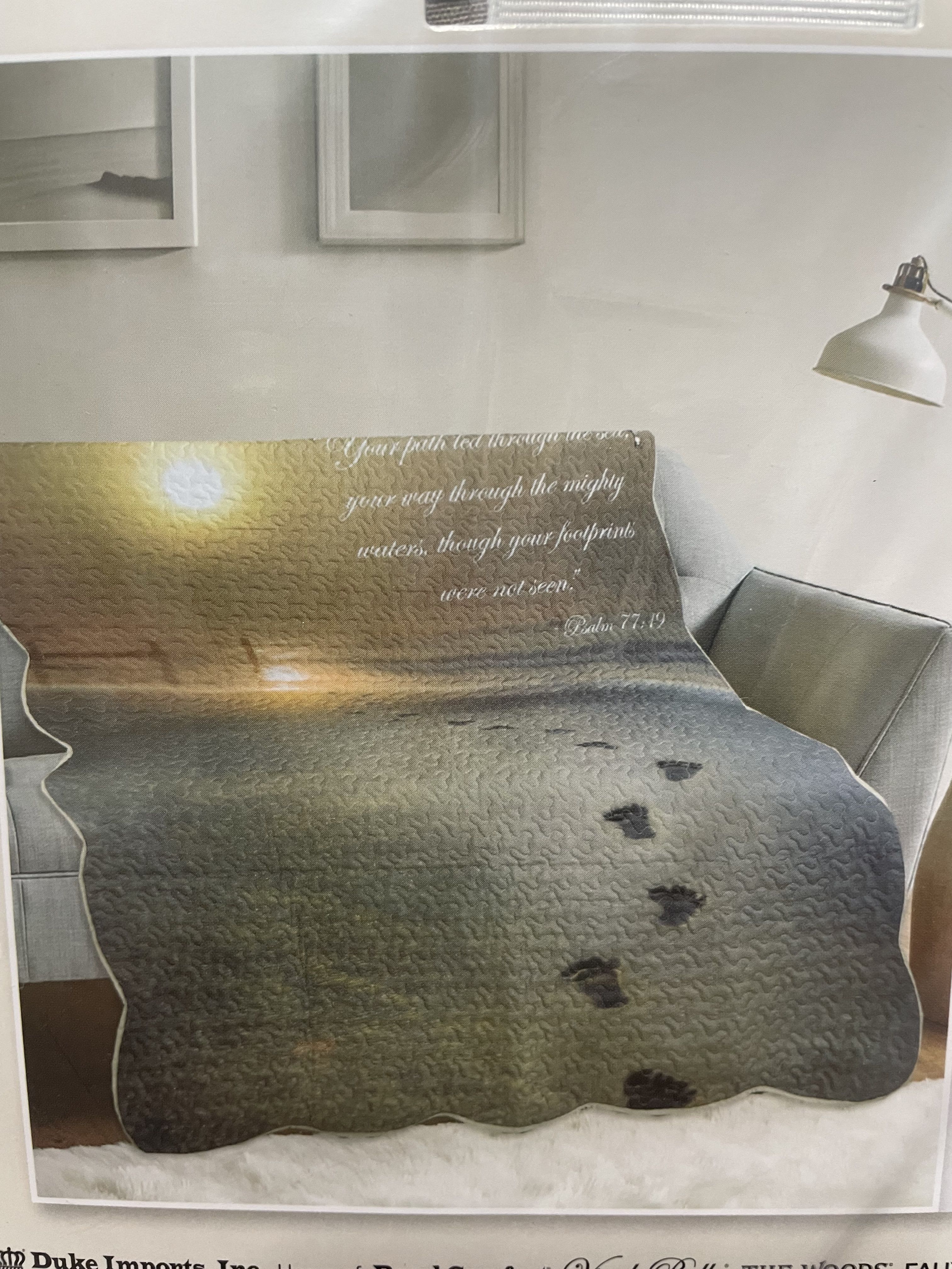 Printed blanket on a sofa with a sunset scene and Bible verse