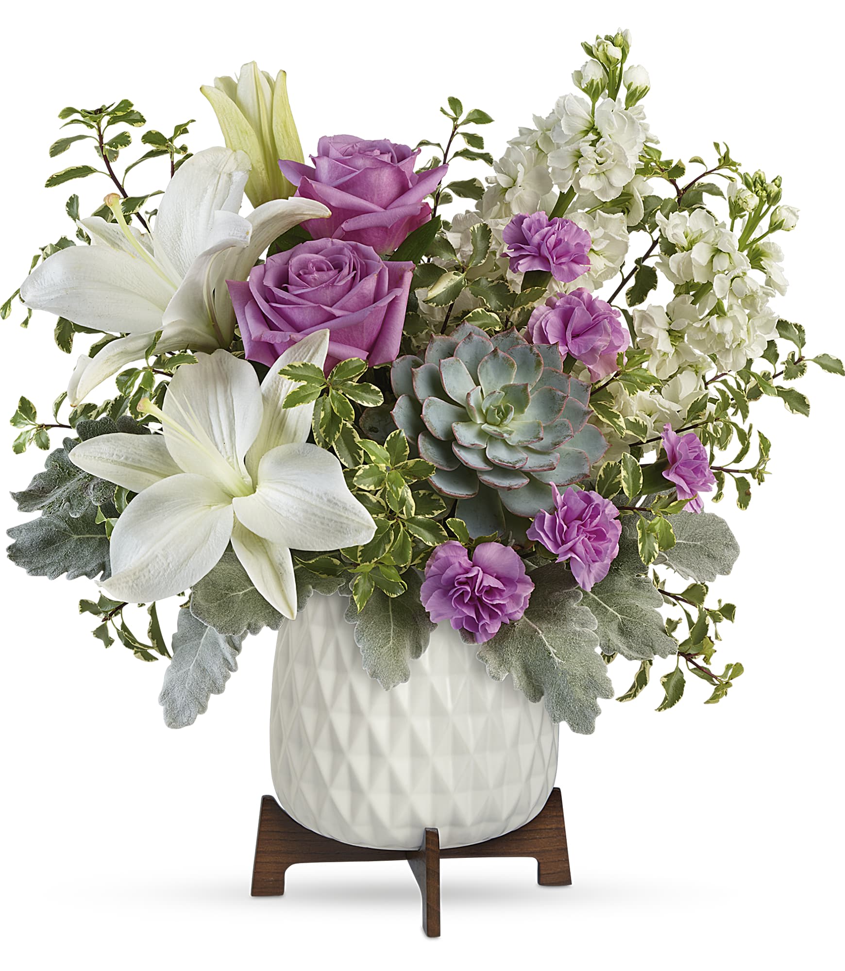 Garden Oasis - Straight out of a mid-century design magazine, this chic planter is the perfect vessel for wondrous white lilies, lavender roses and a stunning living succulent plant. This gorgeous bouquet includes lavender roses, white asiatic lilies, miniature lavender carnations, white stock, pitta negra, dusty miller, and a large echeveria succulent plant. Delivered in a Mid Mod Geometric Planter. Approximately 14 3/4" W x 13 1/4" H TEV58-8A  