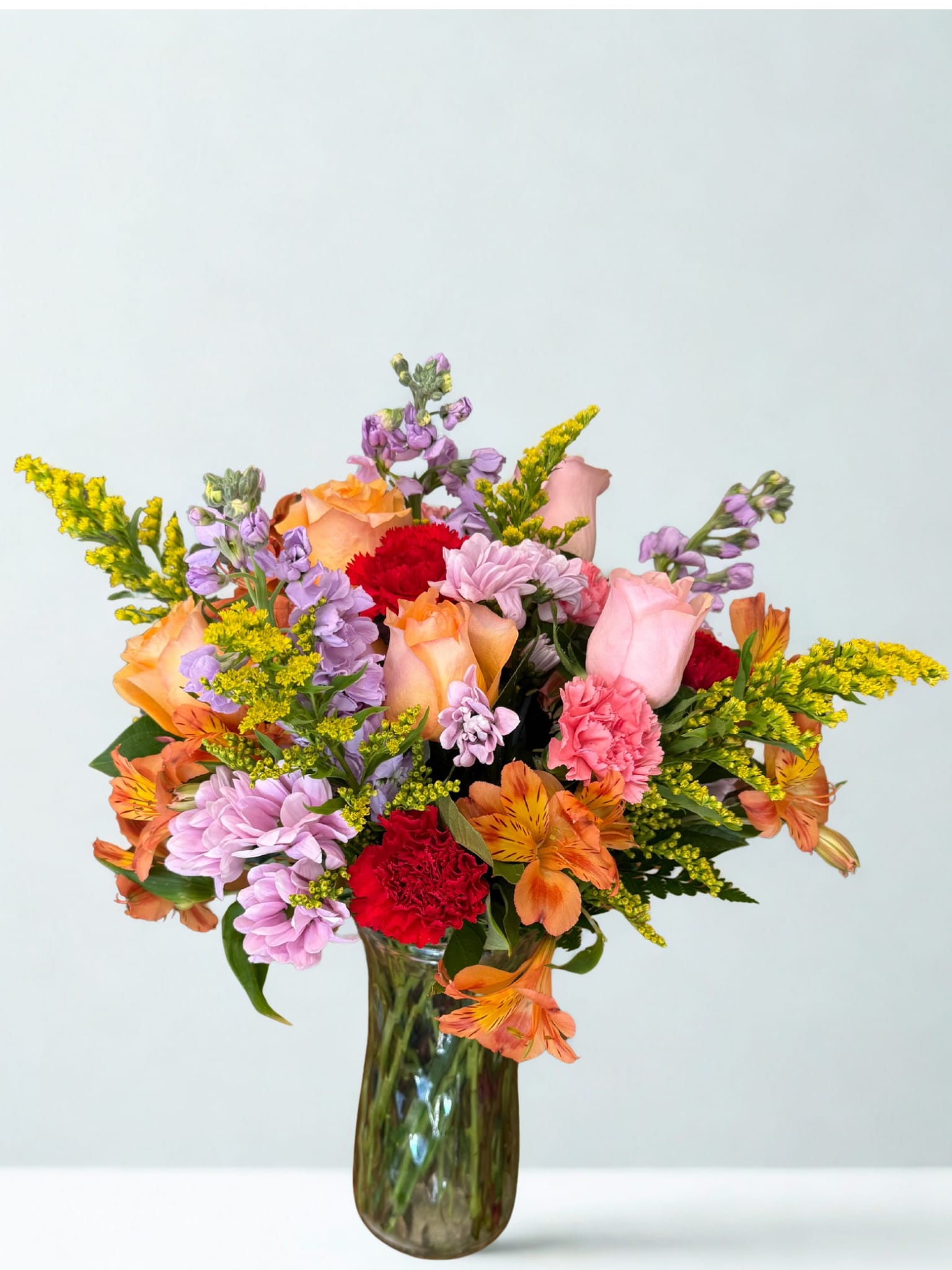 Life of the Party bouquet - Celebrate good times with this lively bouquet. The arrangement includes roses, carnations, alstroemeria, stock, aster, and other seasonal blooms.  This is the perfect gift for Mother's Day, Birthday, or Just Because. APPROXIMATE DIMENSIONS: 12" D x 15"H