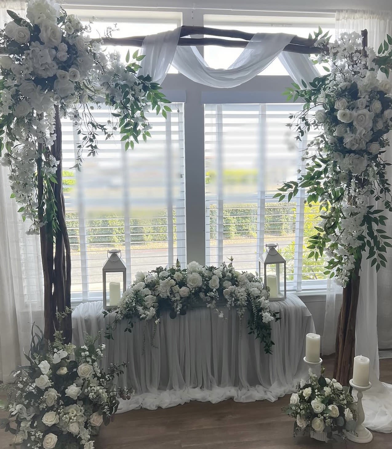 White and soft green Wedding package  - A soft, romantic wedding arrangement built around a white-draped wooden arch that bathes the ceremony in ivory roses, creamy hydrangeas, delicate orchids and airy daisies-perfect for a wedding ceremony or vow exchange.   This wedding flower arrangement has 2 arch pieces, one arrangement for Sweetheart table and centerpieces will be included depending on the customers demand . 
