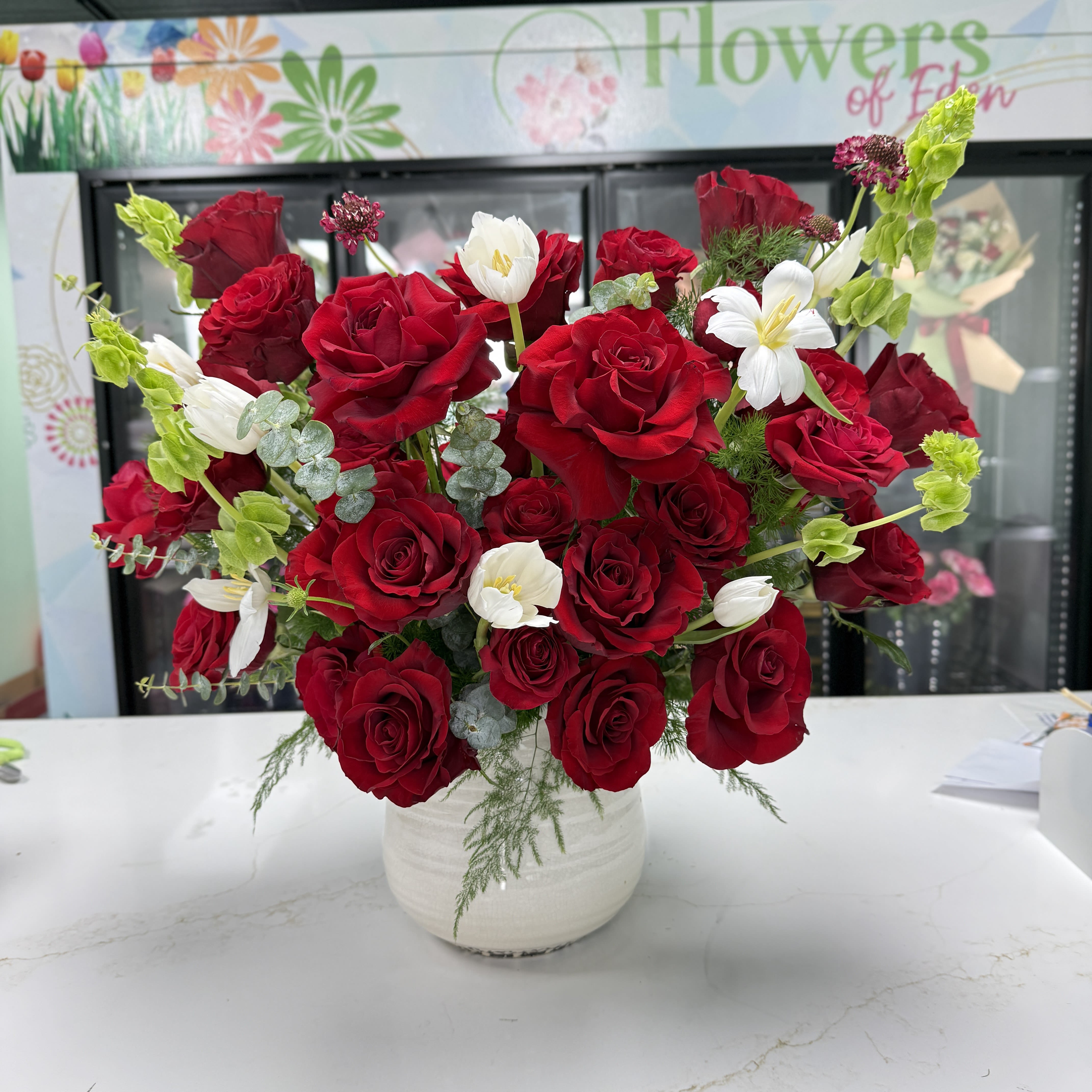 Red Rose Vase 01 - Deep red roses with white tulips and green accents in a white ceramic vase - a lush, romantic arrangement perfect for anniversaries or Valentine's celebrations.