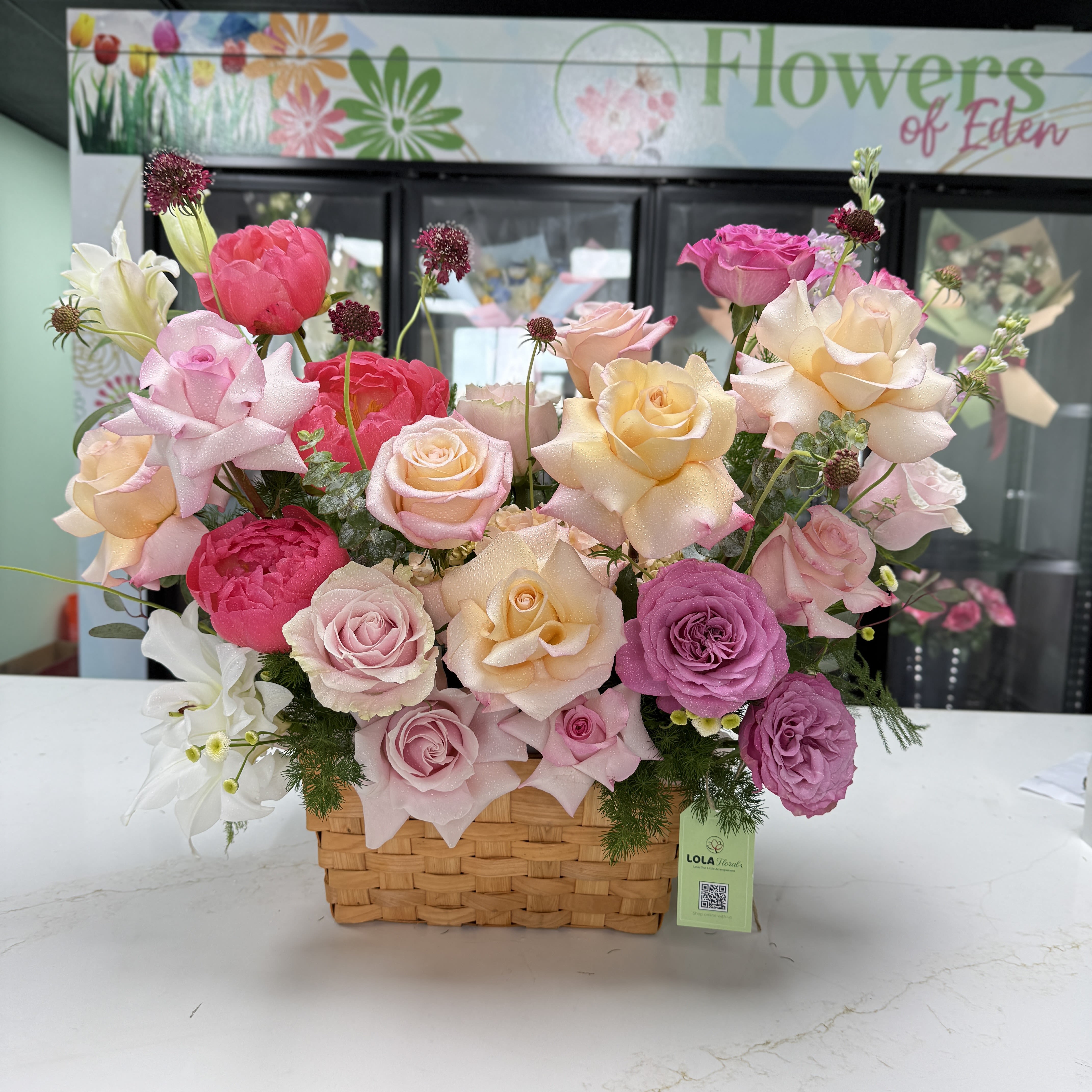 Beauty Basket Bundle  - Roses in pink, peach, purple and cream arranged with airy accents in a woven basket-soft, romantic and cheerful, perfect for springtime celebrations or gifting with a floral tag.