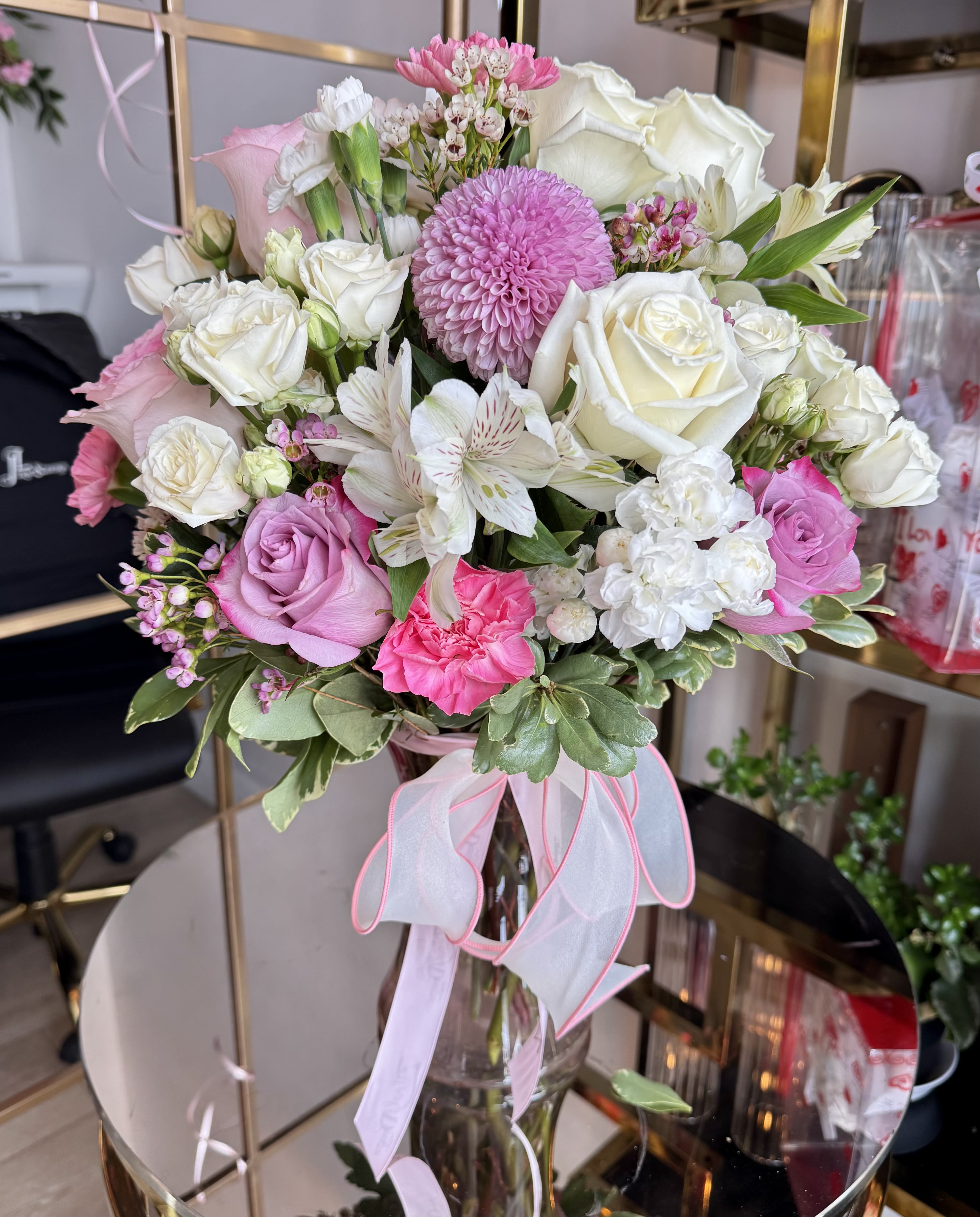 Blush Elegance Garden - A romantic and refined arrangement designed to capture soft beauty and timeless charm. Blush Elegance Garden features a luxurious blend of premium white and pink roses, delicate alstroemeria, lush carnations, and a stunning focal pink disbud chrysanthemum. Accented with seasonal blooms and fresh greenery, this arrangement is artfully arranged in a clear glass vase and finished with a soft pink ribbon for an elegant touch. Perfect for birthdays, anniversaries, Mother’s Day, or simply to brighten someone’s day.
