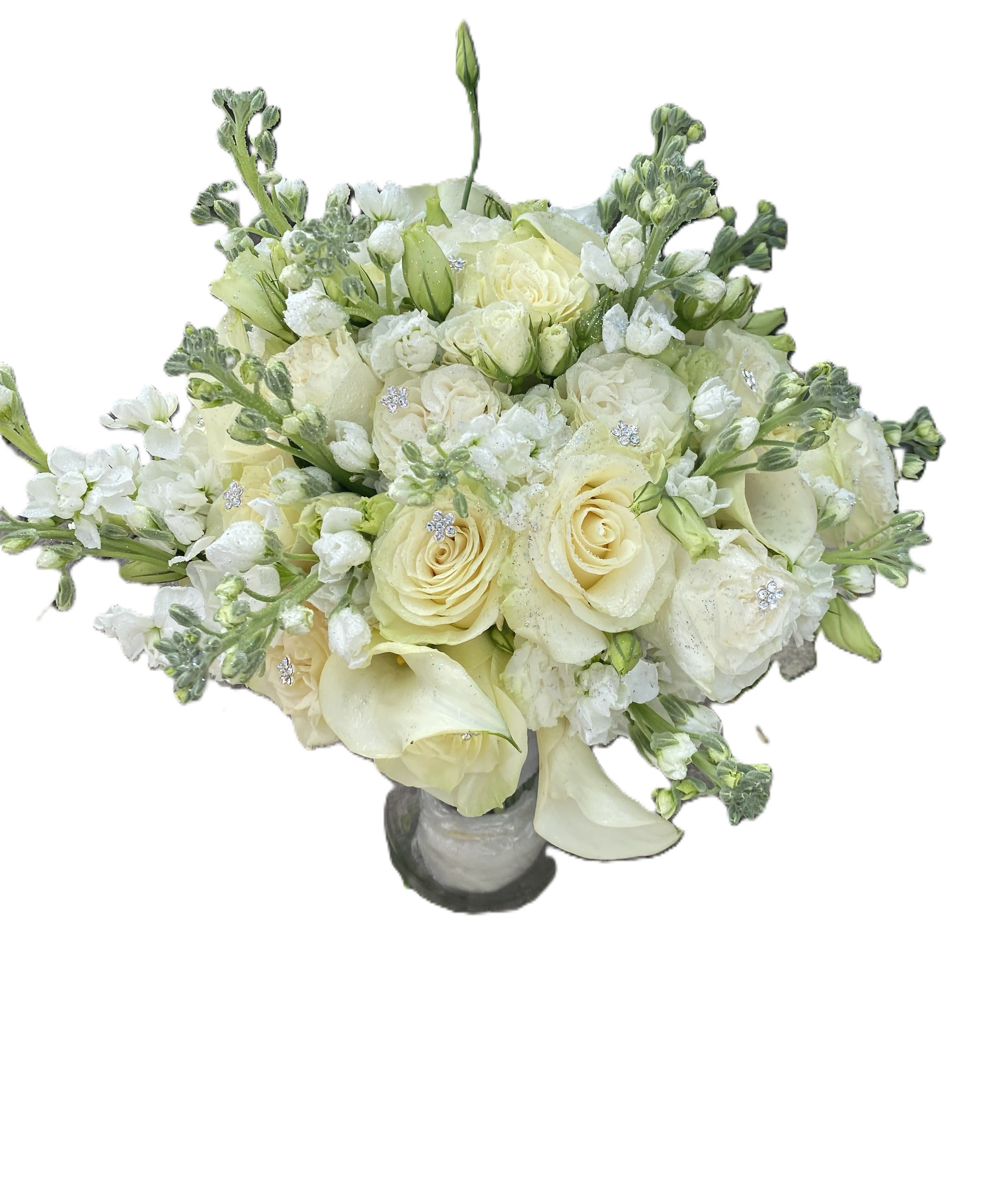 White Bridal Bouquet roses, calla lily, snap dragon  - Ivory and pale cream roses braided with elegant white calla lilies create a classic white bridal bouquet perfect for a wedding or a sympathy arrangement. The rounded, full shape reads formal and refined-she'll feel quietly celebrated by the soft, airy blooms and subtle sparkling accents that catch the light just enough to feel special.  This arrangement pairs roses, calla lilies, and stock (small white filler blooms) in a tightly clustered composition accented with rhinestone floral picks for a gentle shimmer. Hints of green and pale yellow peek through the petals, and a small gray ceramic vase anchors the design so the flowers remain the focal point. Ideal for a bride seeking timeless simplicity or as a tasteful sympathy tribute, the bouquet arrives ready to display in its vase; minimal care-fresh water and a cool spot-keeps the blooms looking their best.