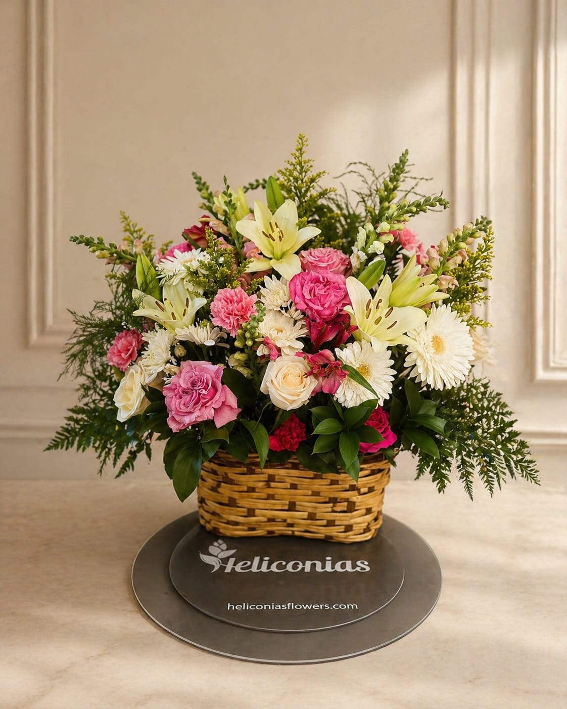 Blush &amp; White Basket - Soft pink roses and pale lilies mingle with white daisies and blush carnations in a low wicker basket-an airy, garden-style flower arrangement perfect for a birthday, a thank-you gift, or a spring celebration. The soft pink, cream and white palette reads feminine and gently romantic, the kind of gift that makes the person you're thinking of feel noticed and cherished.  This full, rounded design sits in a classic wicker basket and features airy greenery and branching accents that extend outward for a lush, natural silhouette. Colors: pink, white, yellow and green; flowers: roses, lilies, daisies, carnations and complementary blooms. Sized as a low basket arrangement, it's easy to place on a table or desk; swap the water daily and trim stems if you transfer to a vase to keep blooms fresh for as long as possible.