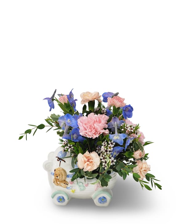 Pink and blue flowers arranged in a decorative ceramic cart