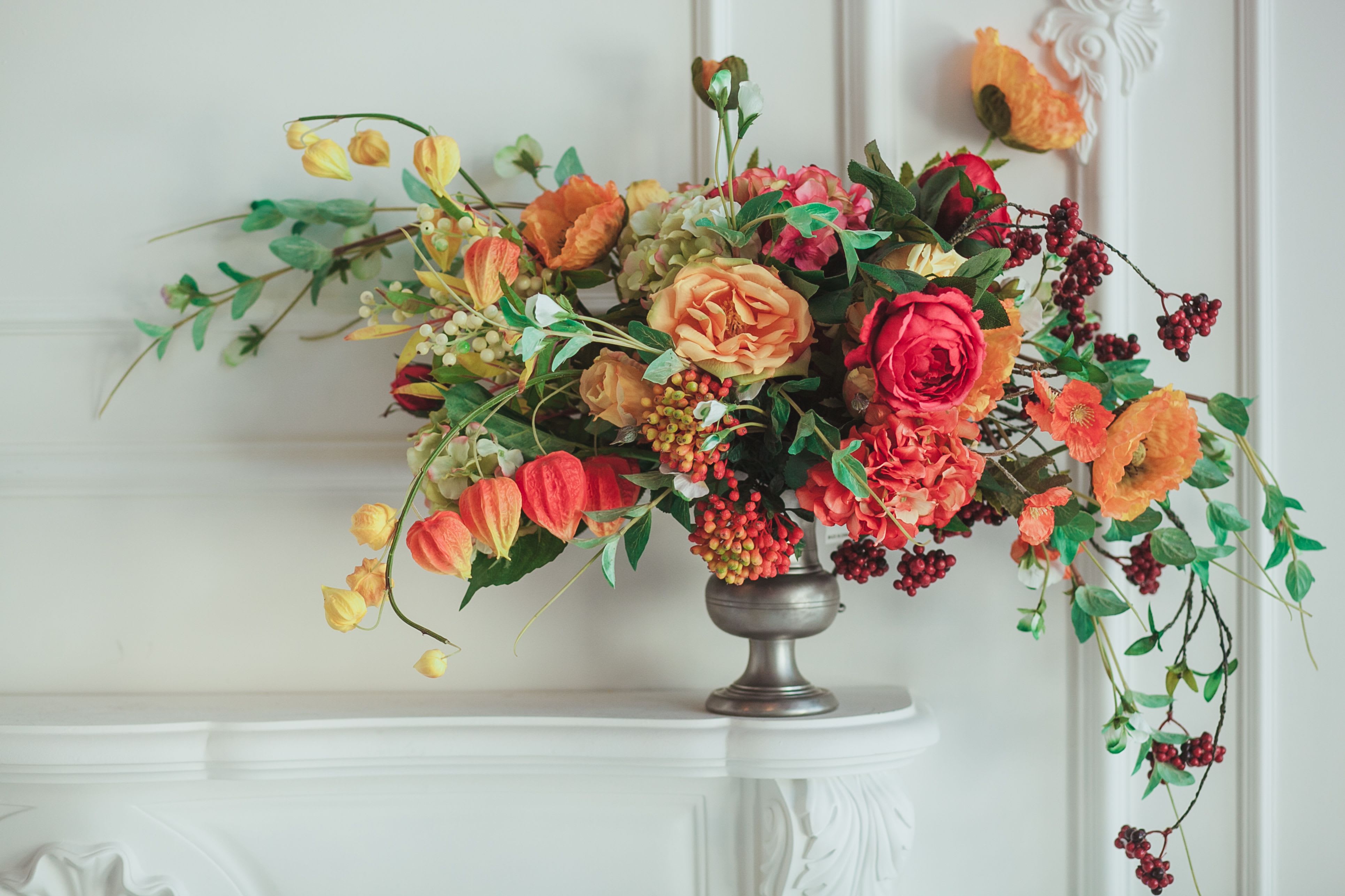 Arrangement of orange and pink flowers in a silver vase