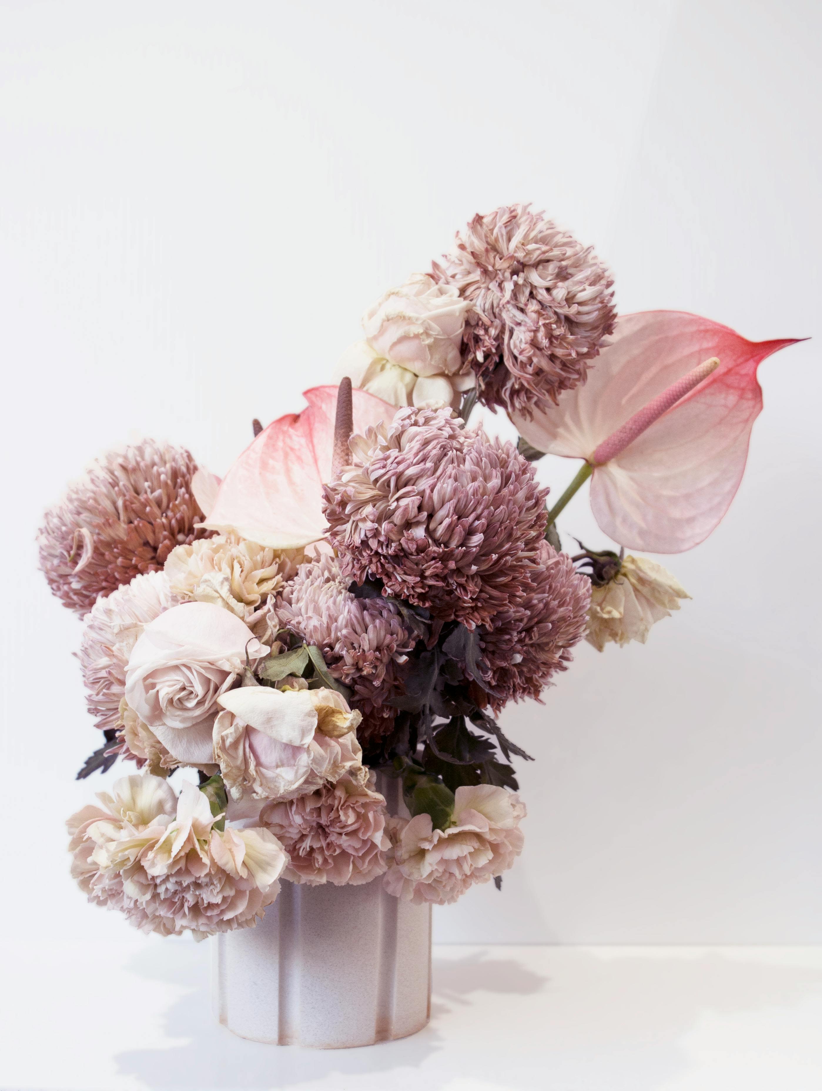 Pink and cream floral arrangement in a pale vase