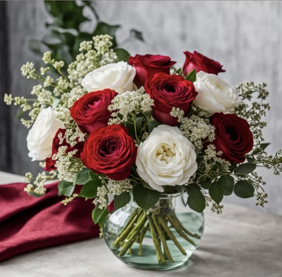 Red and white ranunculus bouquet in a clear glass vase