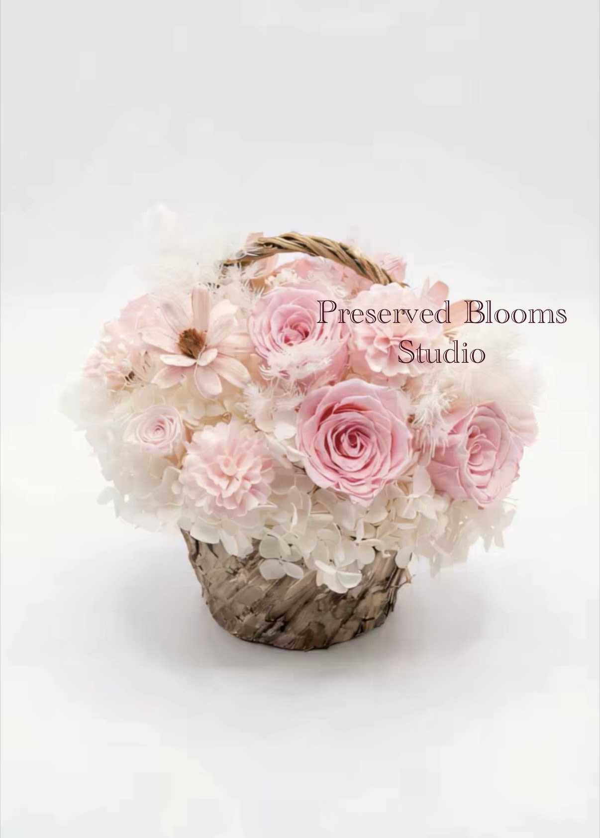 Pink and white roses arranged in a small woven basket.