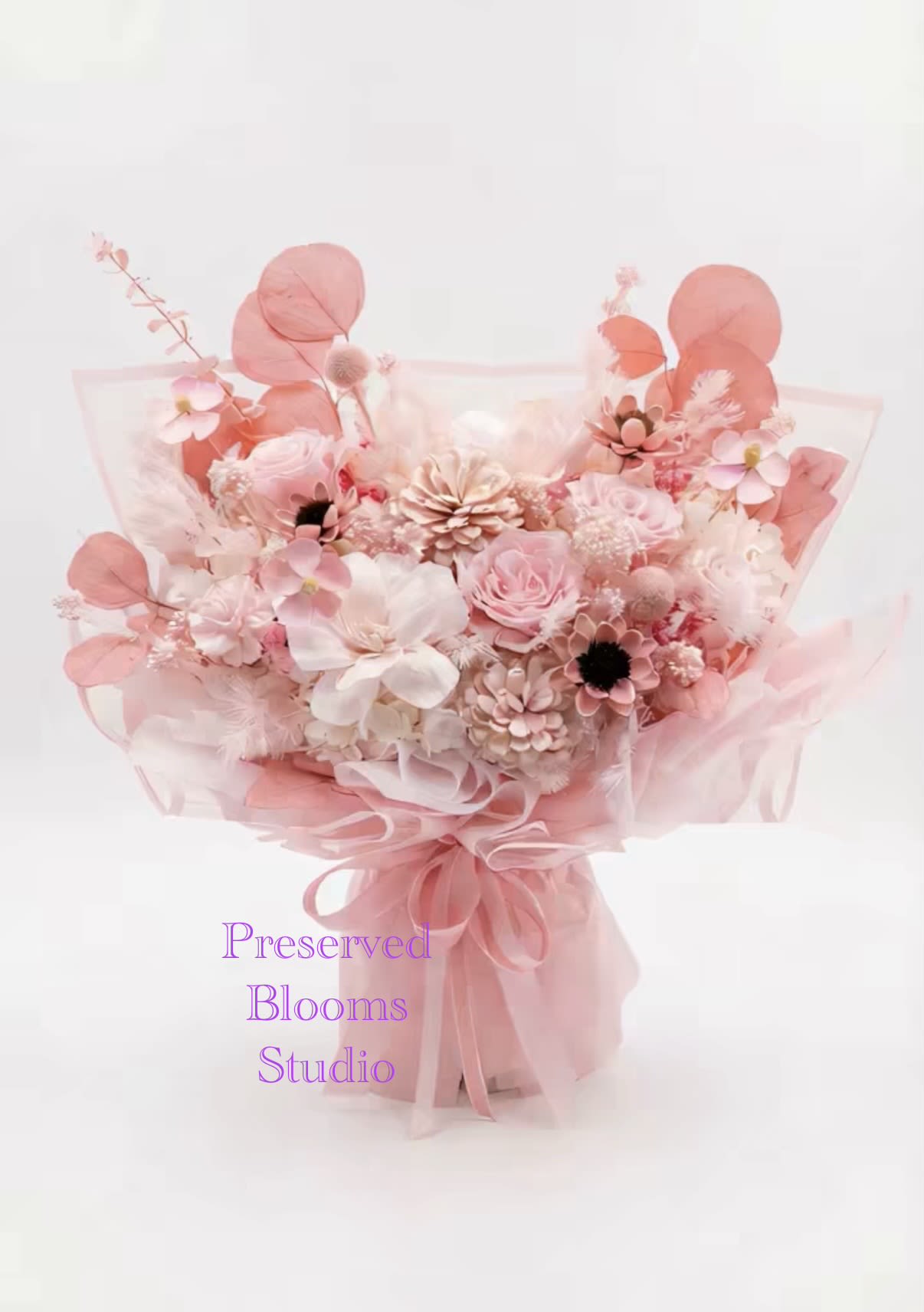 Pink preserved flower bouquet wrapped in sheer pink paper