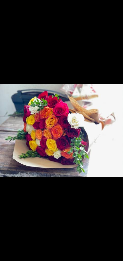 Bouquet of multicolored roses wrapped in tan paper