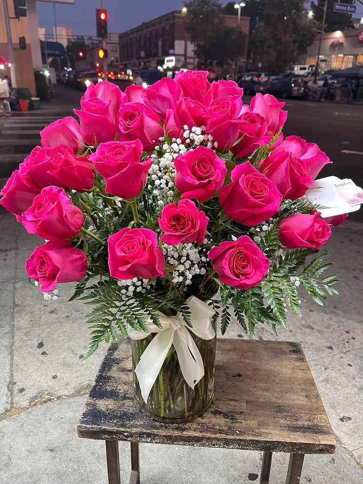 Hot pink roses in a glass vase with white baby's breath