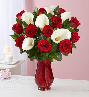 Red roses and white calla lilies in a red glass vase