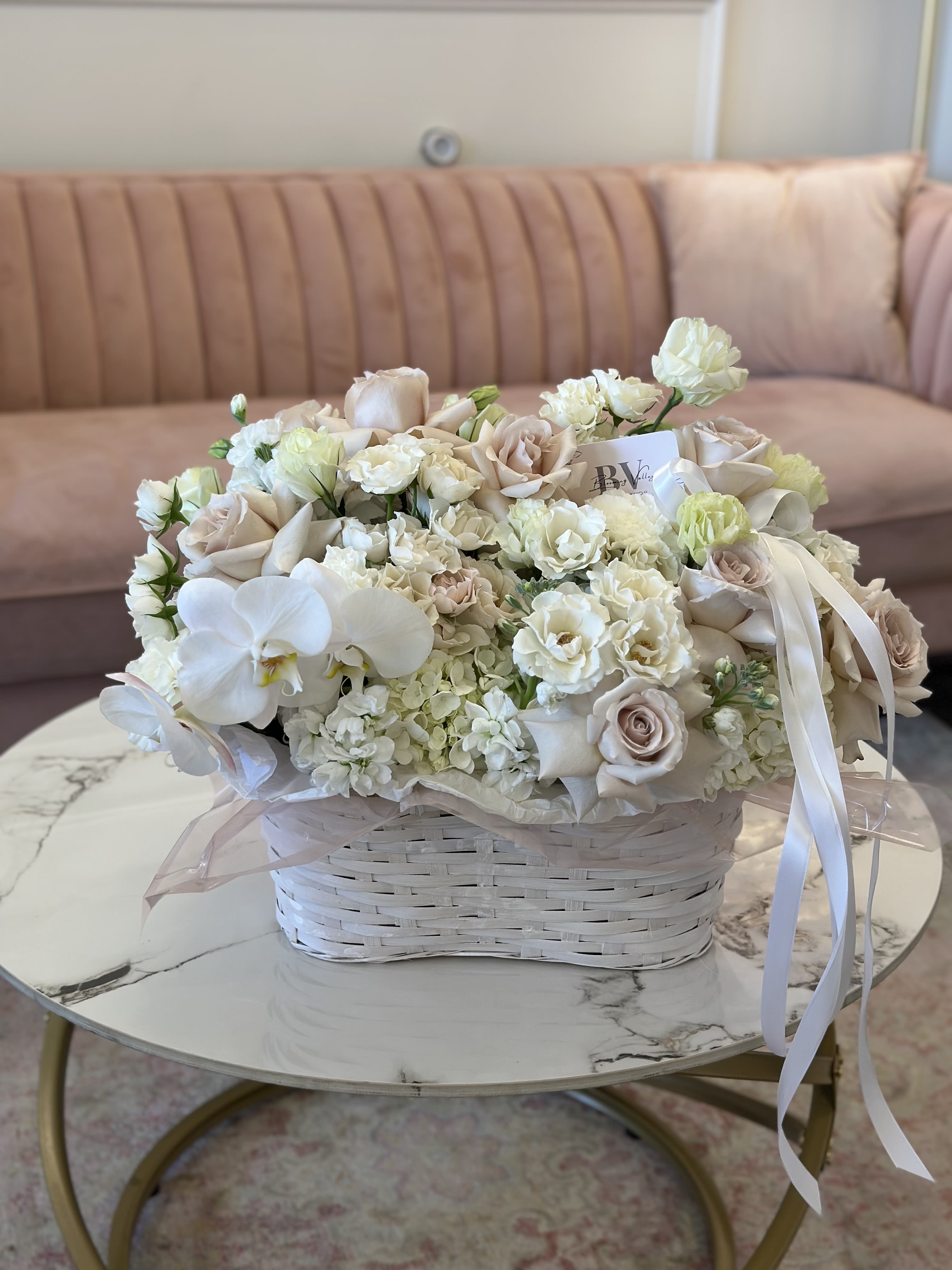 Cream and blush bouquet in a white basket with ribbon