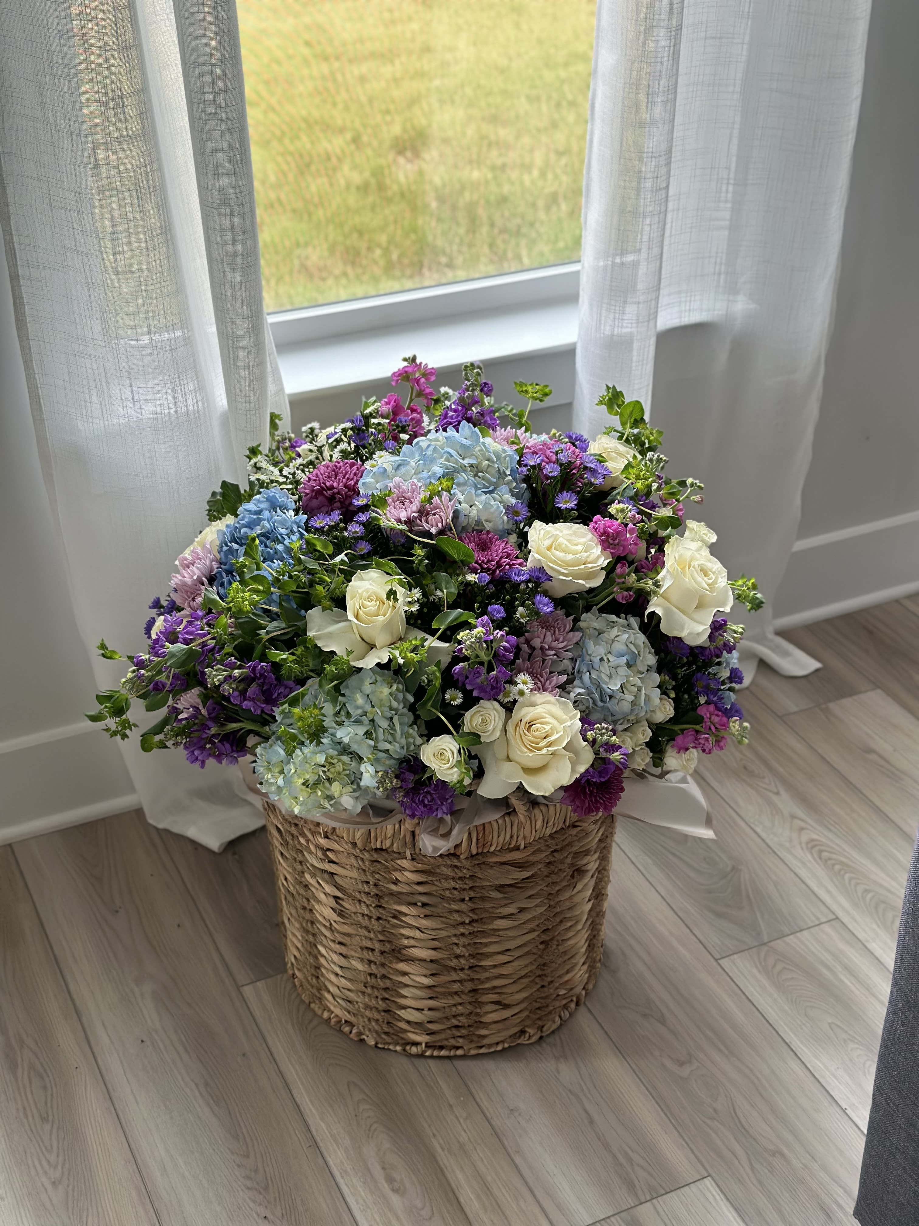 Large mixed flower arrangement in a woven basket