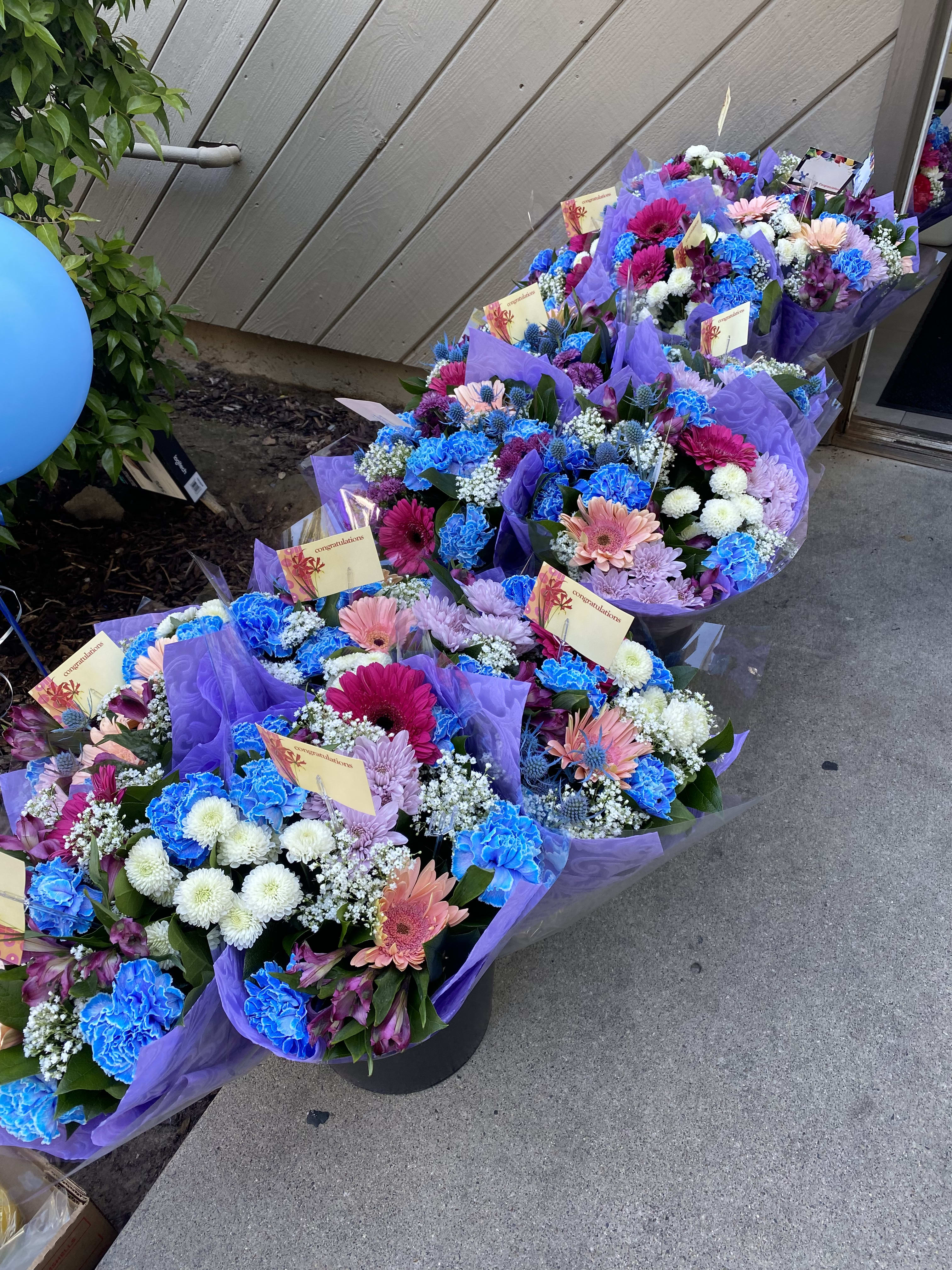 Bouquets of colorful mixed flowers wrapped in purple paper
