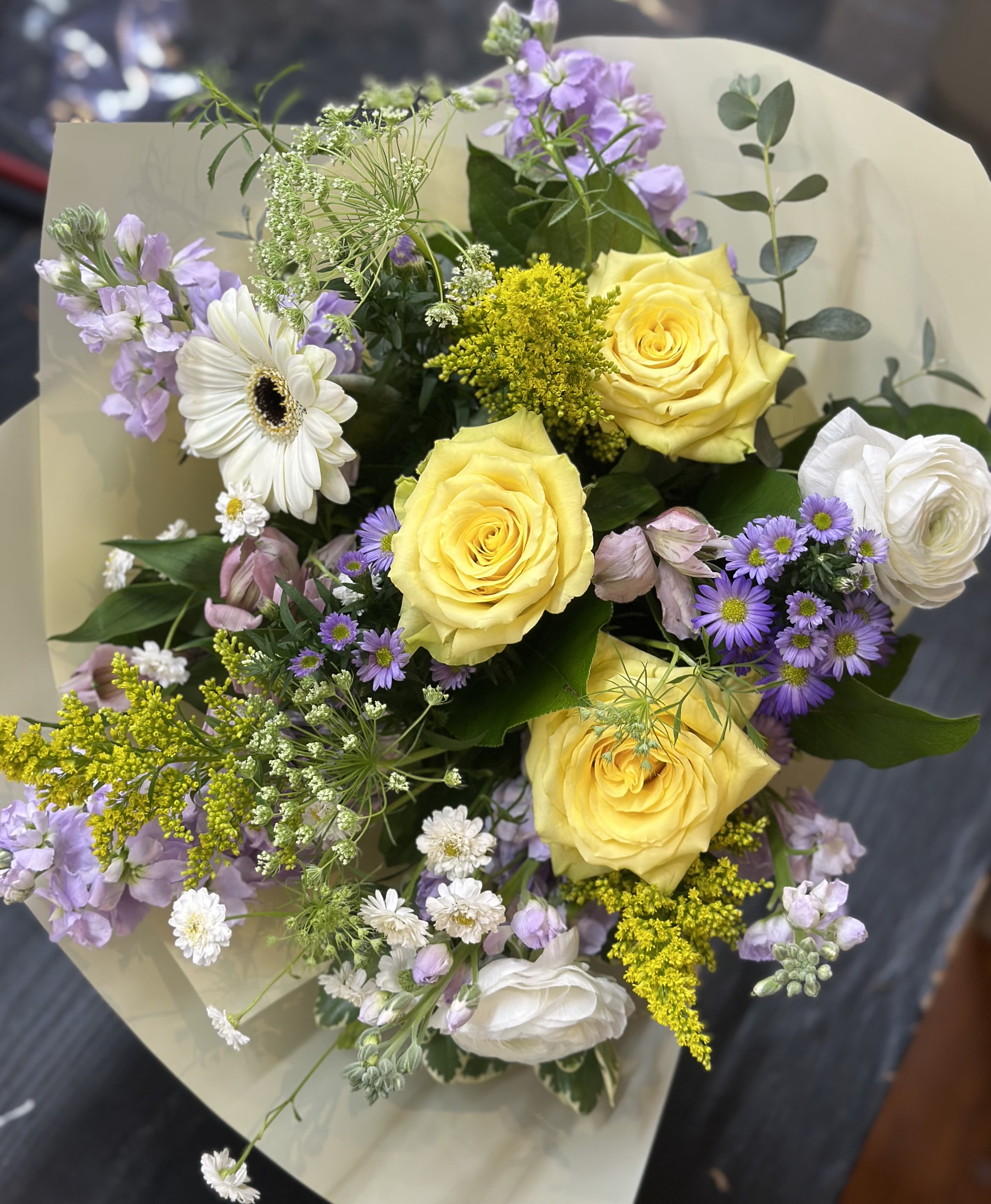 Gemini - Born from May 21st to June 20th, Geminis are curious, expressive, and endlessly vibrant. Known for their playful spirit and love of connection, they bring lightness and energy wherever they go. Our Gemini Zodiac arrangement features cheerful yellow roses, whimsical white blooms, airy lavender florals, and textural accents. Bright and soft, this design reflects the charm, creativity, and joyful duality of this air sign.