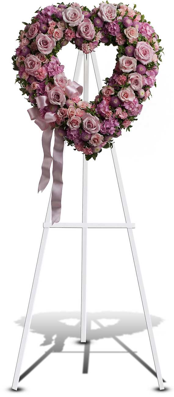 Heart-shaped pink floral wreath on a white easel with ribbon
