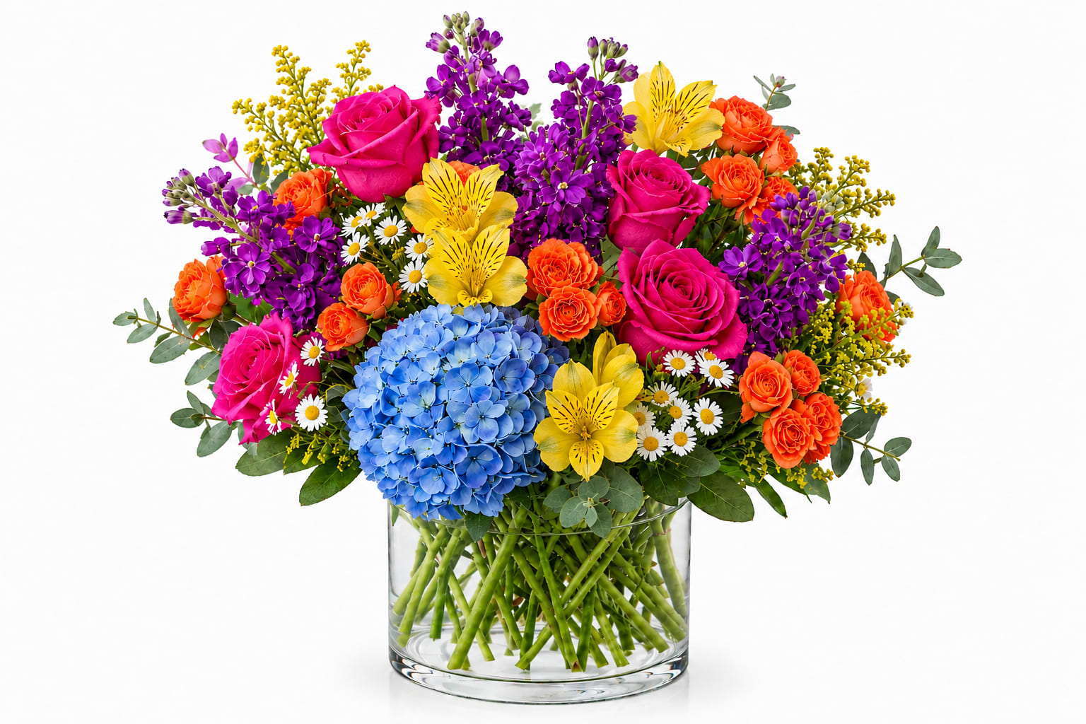 Whimsical Summer  - A bold and cheerful summer arrangement bursting with vibrant spray roses, fluffy purple stock, blue hydrangea, sunny Alstroemeria, and playful seasonal blooms in a clear glass vase.  *Vase/container may vary depending on availability of stock at time of purchase. *We strive to use the flowers shown whenever possible; however, substitutions of equal or greater value may be made based on seasonal and market availability. 