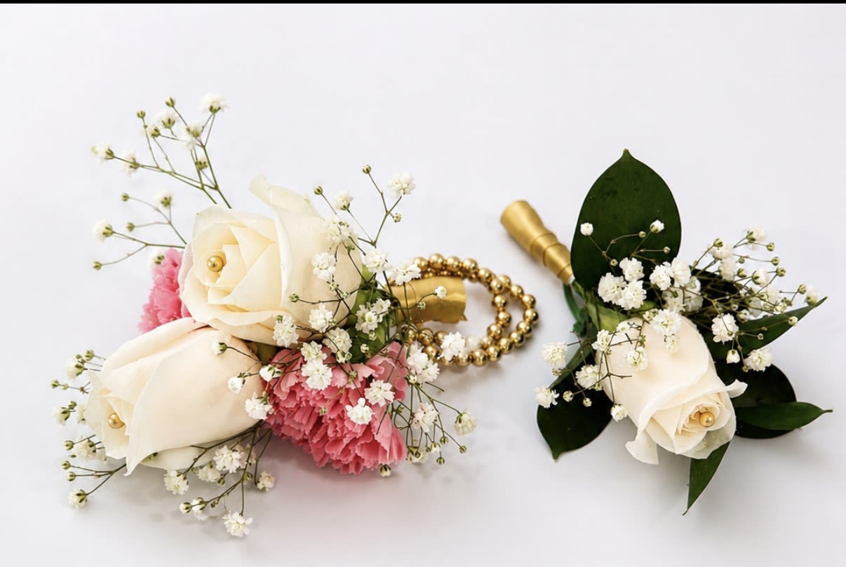 GOLD CORSAGE AND BOUTONNIERE  - Cream roses and pink carnations mingle with touches of baby's breath and deep green foliage in this elegant corsage and boutonniere set-perfect for weddings, proms, or any dressy occasion where you want the person you're giving it to to look and feel celebrated. The pairing reads romantic and refined: the wrist corsage sits like a small armful of blooms, while the matching boutonniere offers a complementary, polished accent for a lapel.  Gold details-an included beaded bracelet, gold ribbon, and floral corsage pins-lift the arrangement with a subtle metallic sheen that catches light in photos and adds formal flair. The color palette of cream, soft pink, and leafy green keeps the look timeless and easy to coordinate with dresses, suits, or bridal party palettes. Sized for wear, these pieces arrive ready to pin or fasten; for best results, keep cool and mist lightly before the event to preserve freshness.