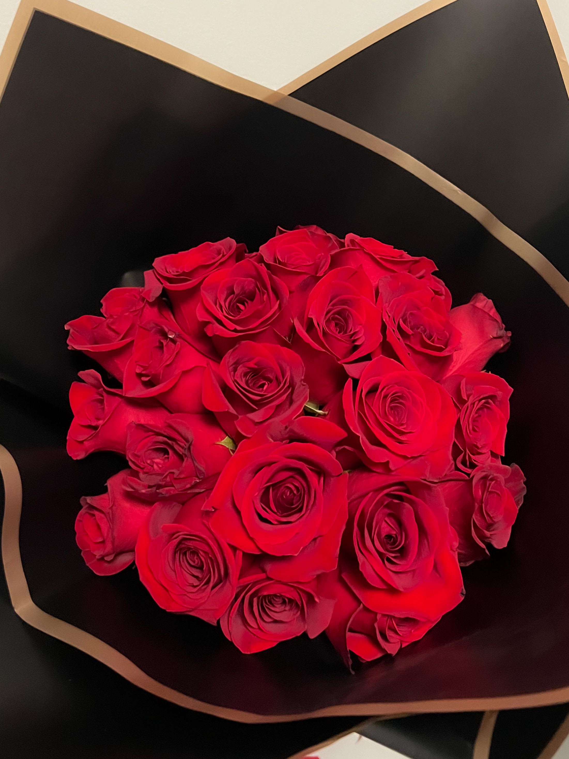 Bouquet of red roses wrapped in black paper