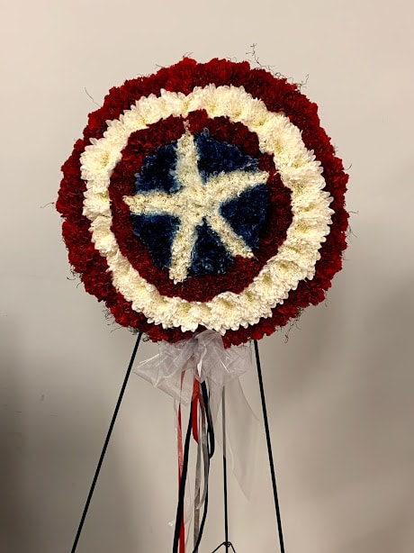 Round floral wreath in red, white, and blue on a stand
