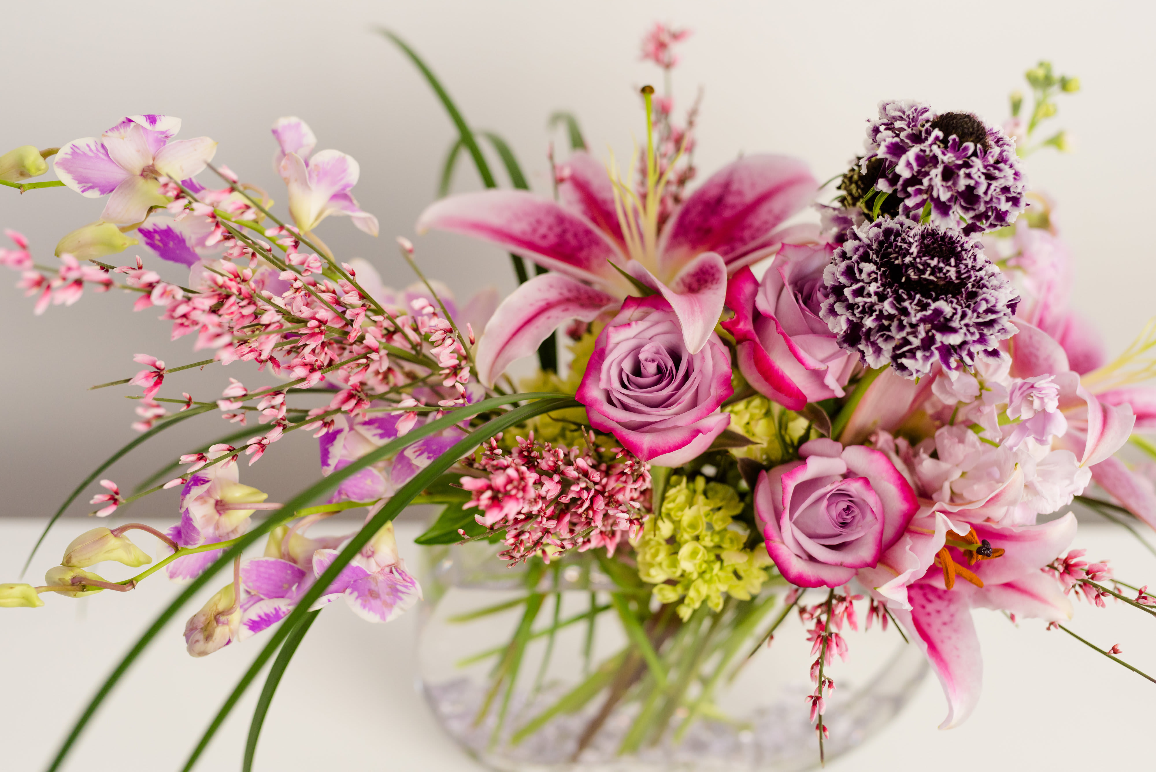 Pink and lavender floral arrangement in a clear glass vase