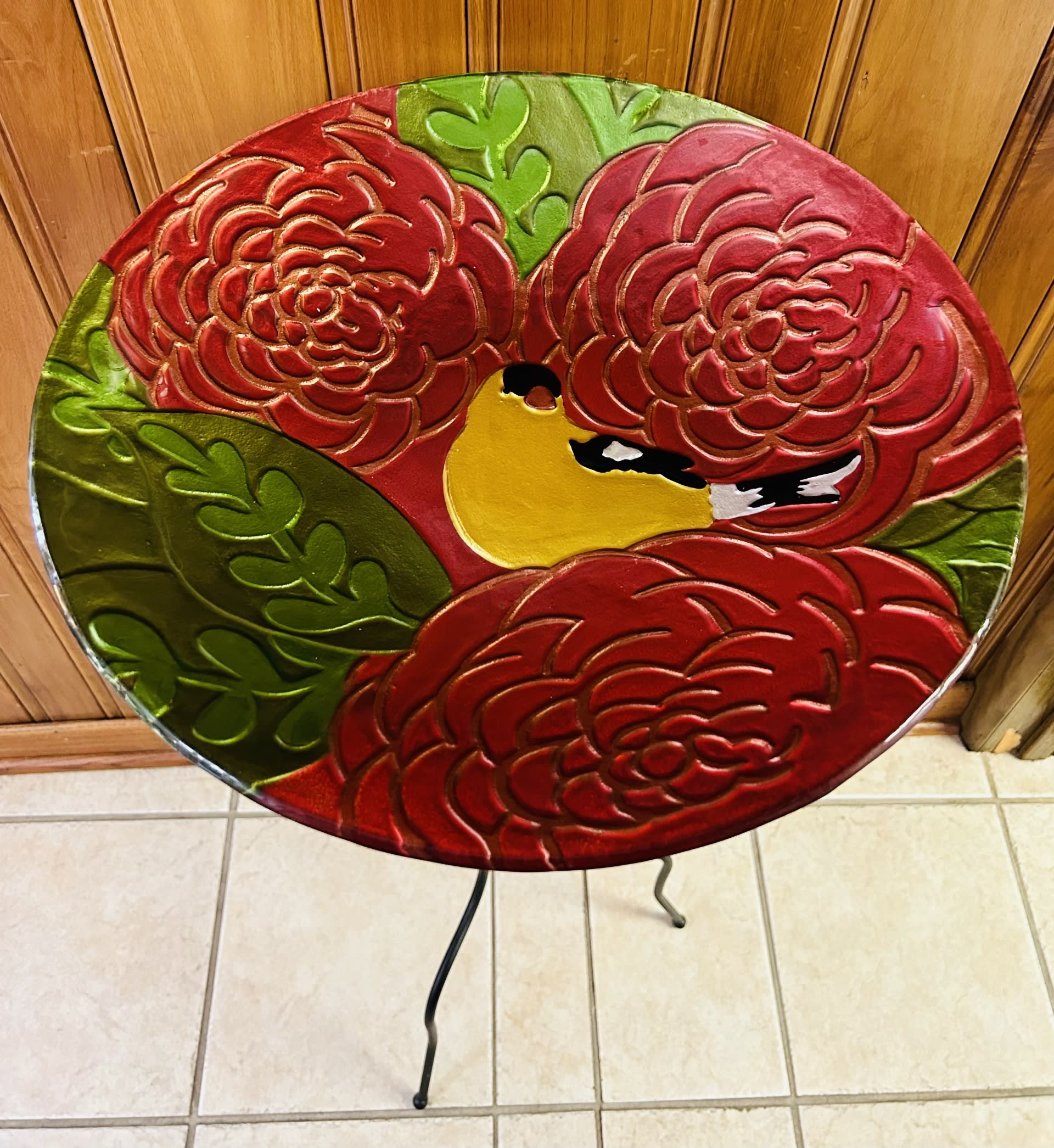 Yellow Bird Glass Birdbath  - A glossy red glass birdbath perched on a tall black metal stand brings a warm focal point to any garden, patio, or entryway-perfect for housewarming gifts, birthdays, or a thoughtful thank-you this autumn. The shallow decorative bowl features an embossed floral pattern that catches sunlight and invites birds to linger, while the rustic contrast between the vibrant red and dark frame creates a charming, cottage-style accent that suits summer afternoons as well as crisp fall mornings.  The piece stands 40 inches tall on a three-legged metal frame with gently curved legs for stable support; the foldable design makes it easy to disassemble and store through the seasons. The bowl's glossy finish and floral embossing add texture and visual interest, and the utilitarian yet ornamental construction means it works equally well as a functional birdbath or a decorative bowl for seasonal displays.  Give someone the small pleasure of watching birds visit-or the perfect decorative touch for a retirement celebration, Mother's Day, or Grandparent's Day. Durable and simple to maintain, this birdbath is a lasting gift that makes the recipient feel seen and cared for; order now to add an enduring, welcoming accent to their outdoor space.