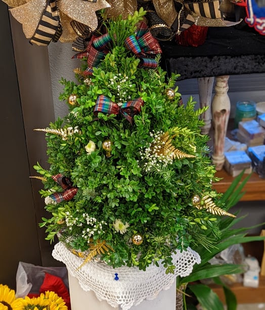 Small Christmas tree made of greenery with plaid bows and gold ornaments
