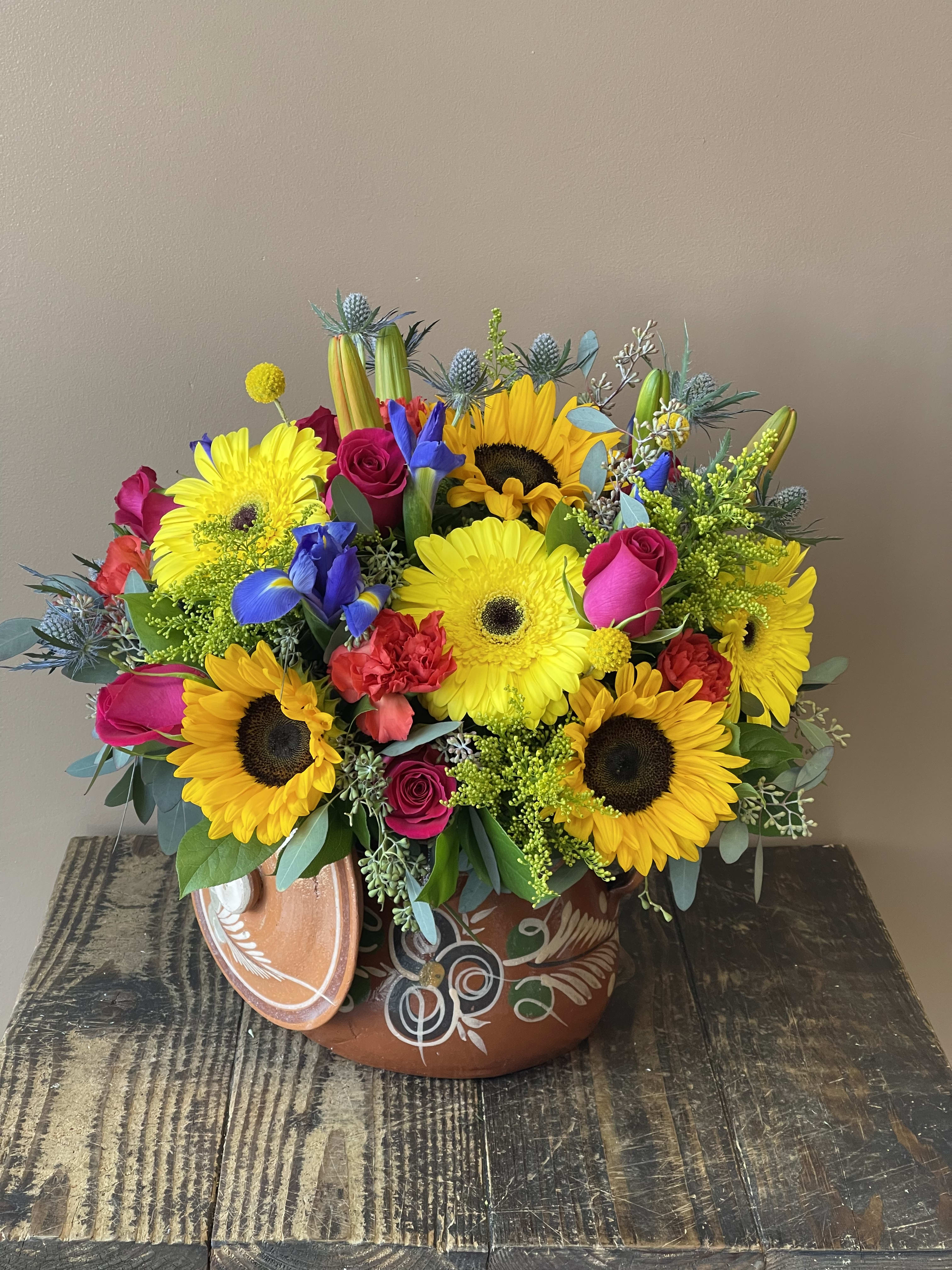 Flores delJardín - Vibrant and colorful flowers arranged in a keepsakes cooking pot. Perfect for any occasion! Dimensions are 16x16 