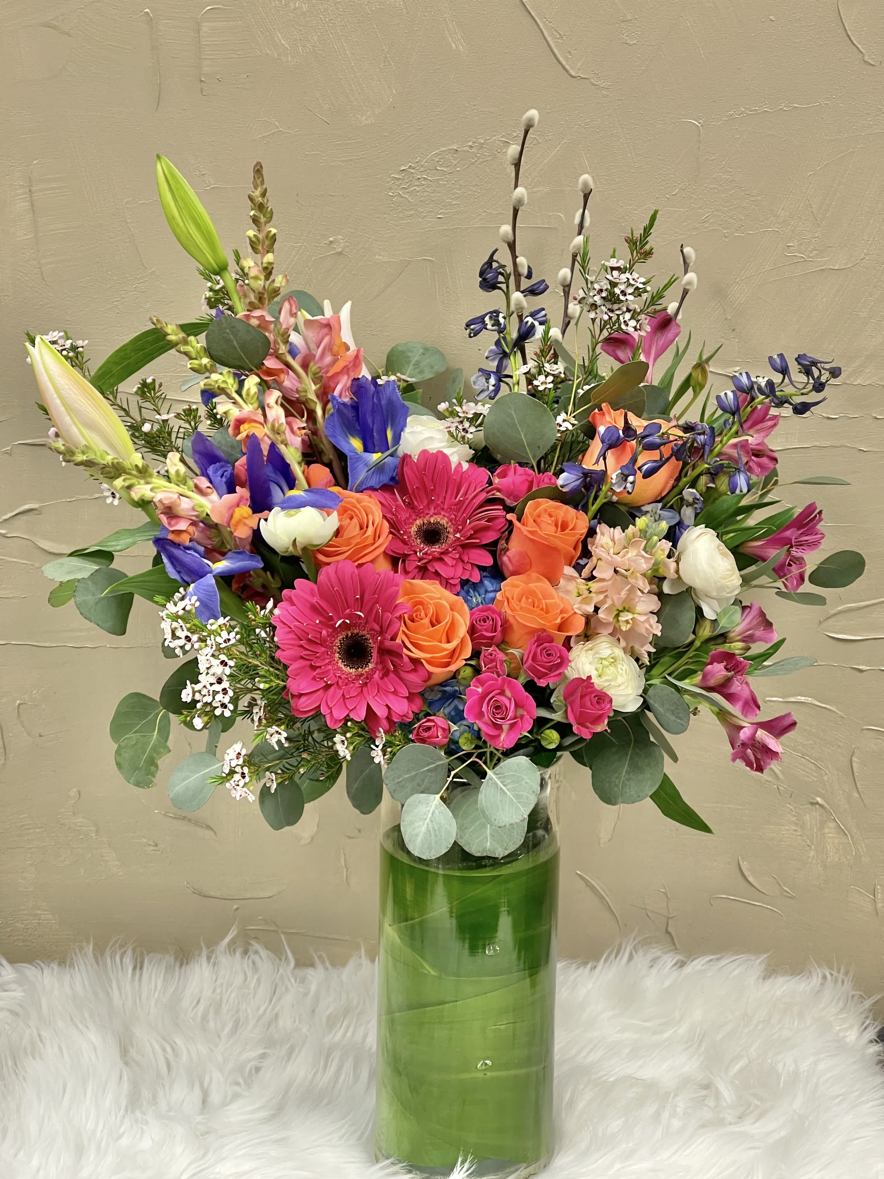 Colorful mixed bouquet in a tall glass vase