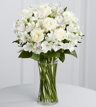 White rose and alstroemeria bouquet in a clear glass vase