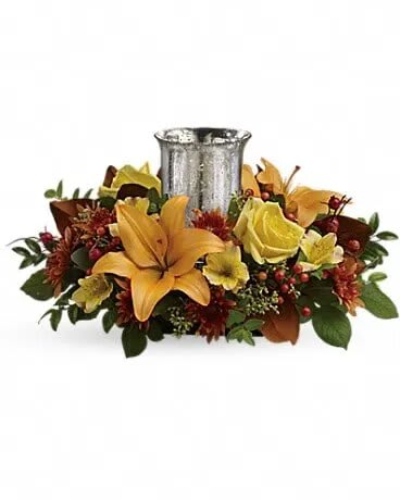 Floral centerpiece with lilies and roses around a silver vase