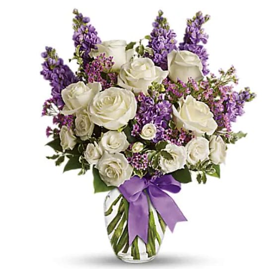 Enchanted Cottage - This magical bouquet will be at home in a cottage, a condo, a studio or an estate. It's so pretty it will be appreciated by all those lucky enough to receive it. Enchant someone today! White roses and spray roses, lavender stock and waxflower, all perfectly arranged in a clear glass vase that's wrapped with purple ribbon.   Orientation : One-Sided  All prices in USD ($)  Standard  T50-1A  Deluxe  T50-1B  Premium  T50-1C