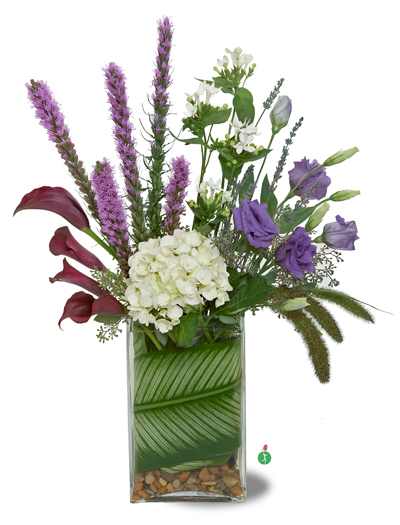 Tall mixed bouquet with purple and white flowers in a glass vase