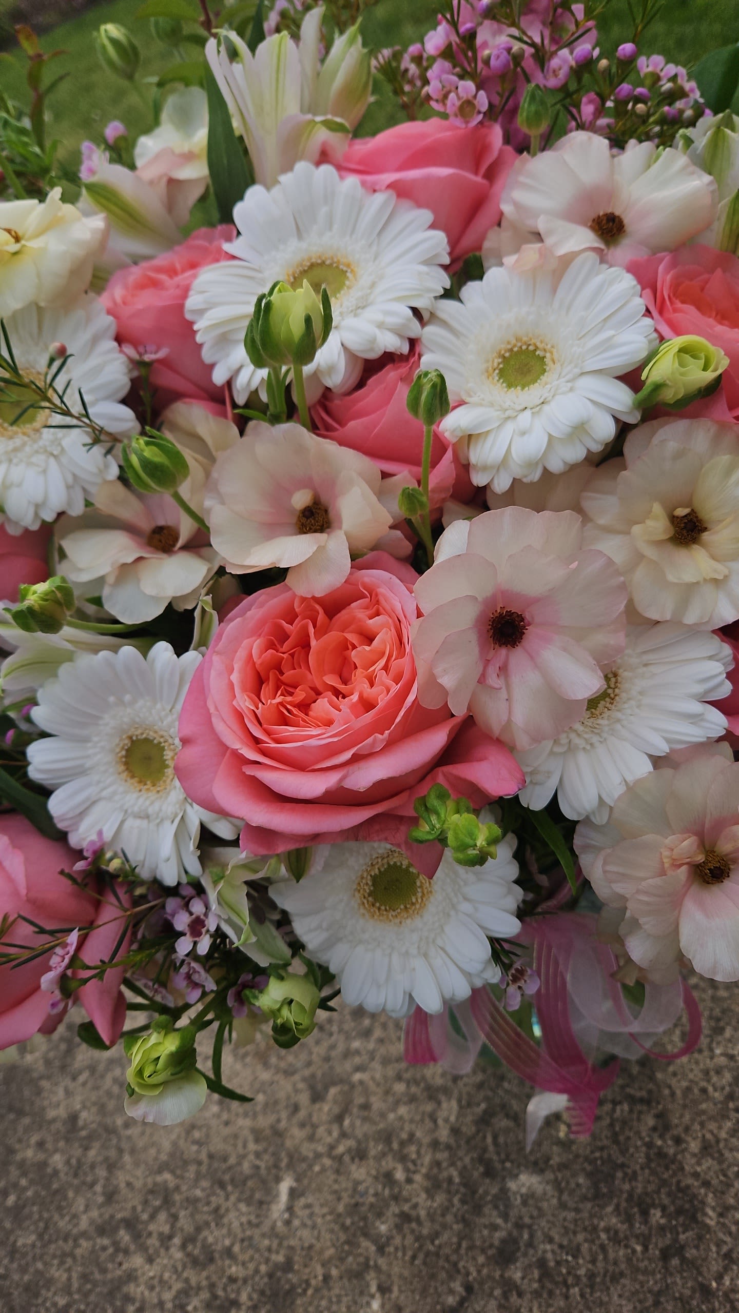 Pink roses and white daisies in a hand-tied bouquet