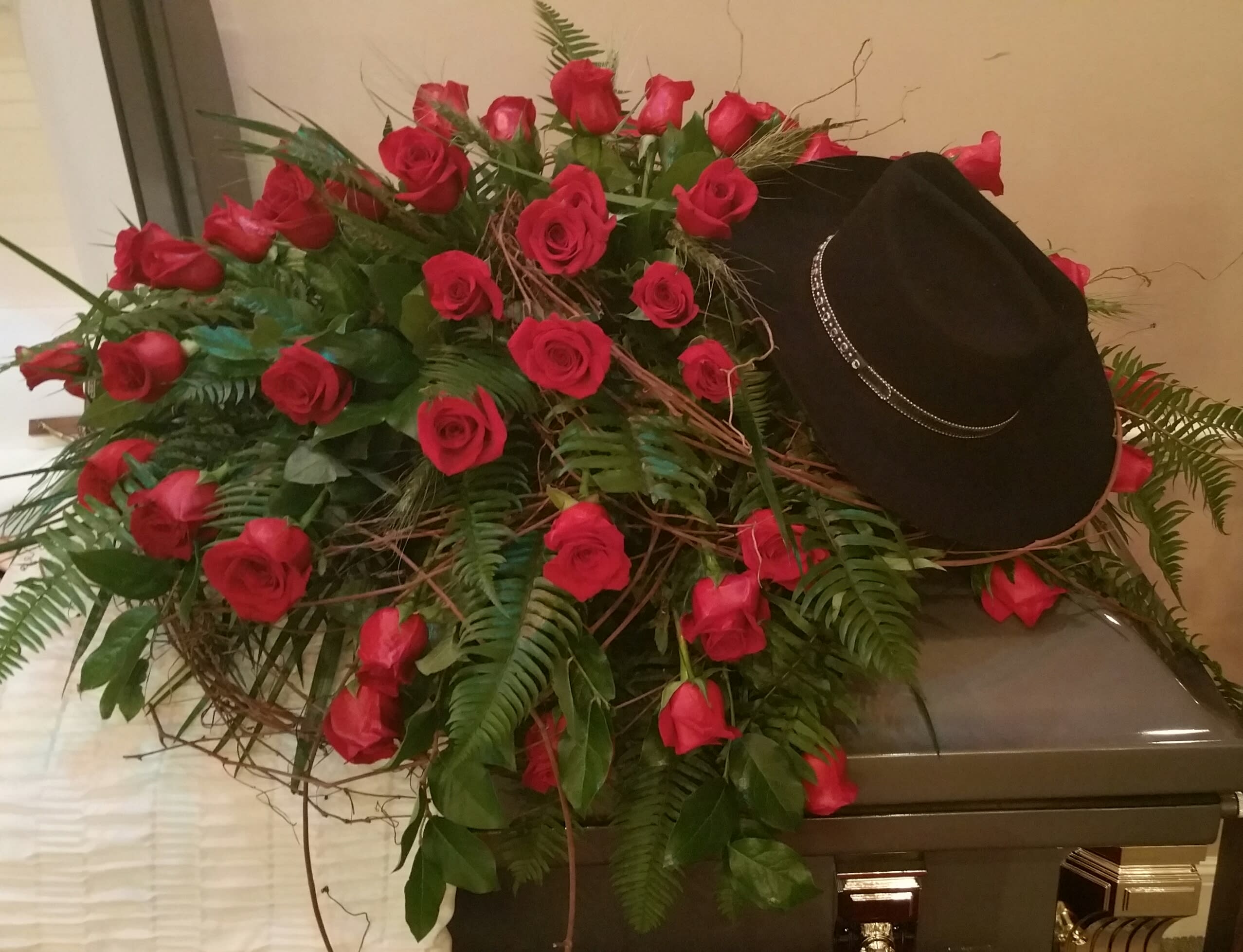 Red Rose Casket Cover - casket cover with red roses, grapevine, and personalized with his very "own" cowboy hat.